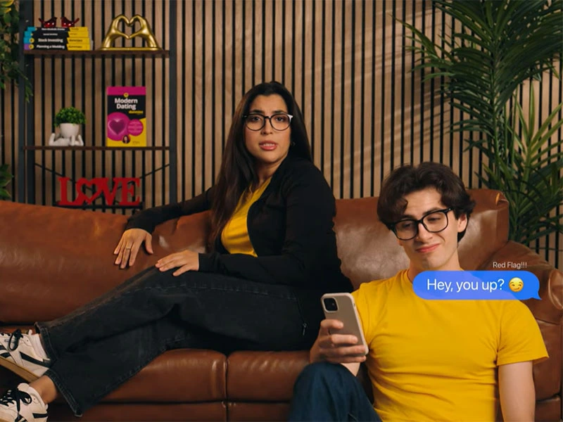 woman sitting on sofa while late night texter man sits on floor in front