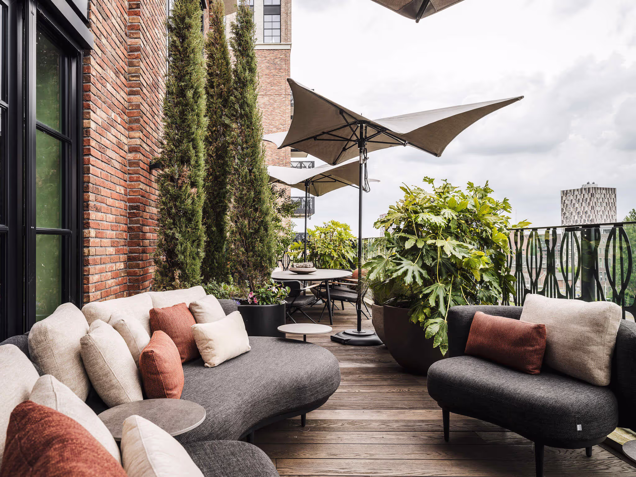 Luxe dakterras in de winter met wintergroene beplanting, beschermde loungeset en Millboard-vlonder – winterklaar gemaakt door Ernst Baas.