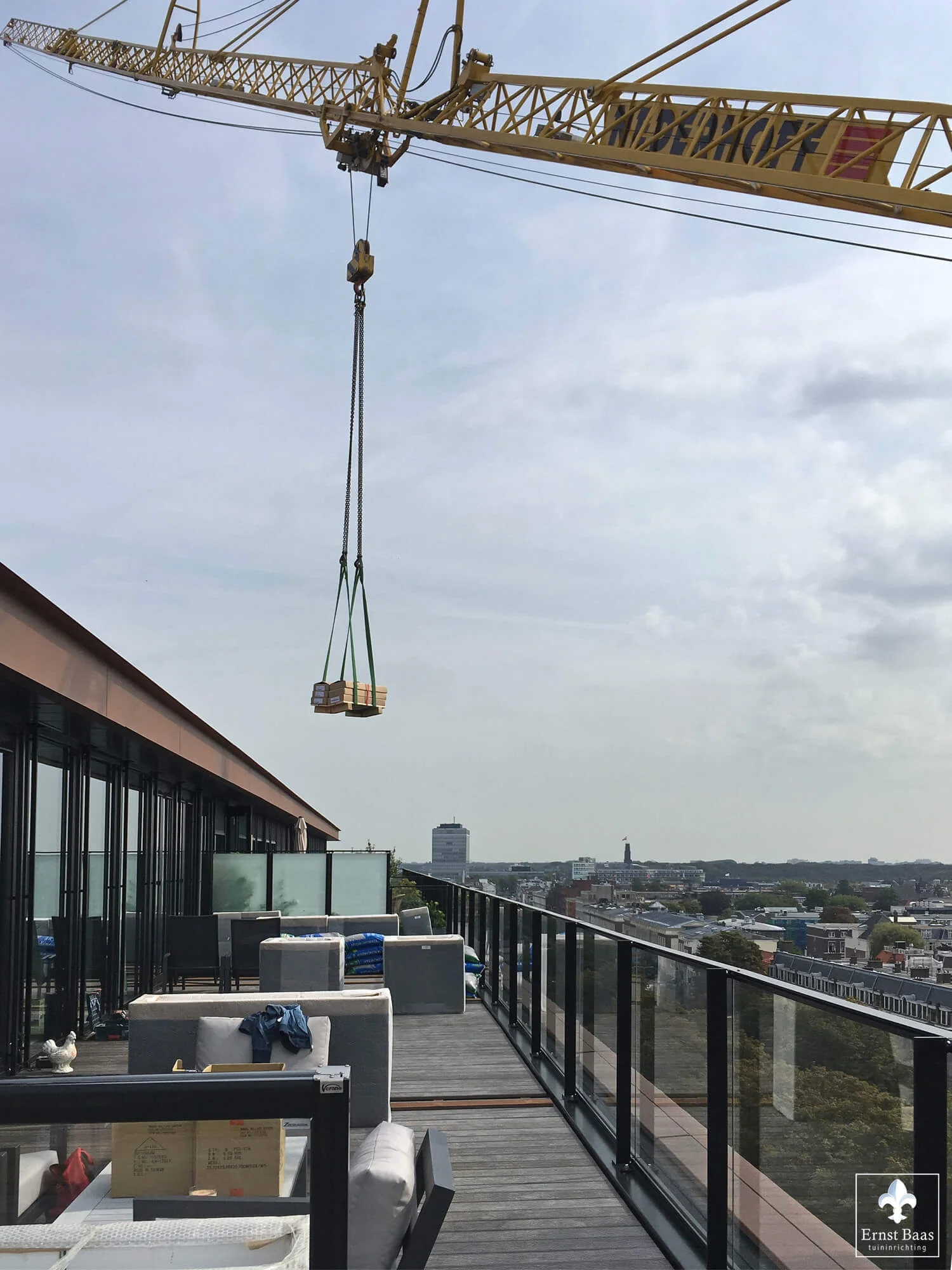 Verticaal transport van luxe tuinmeubelen naar een dakterras