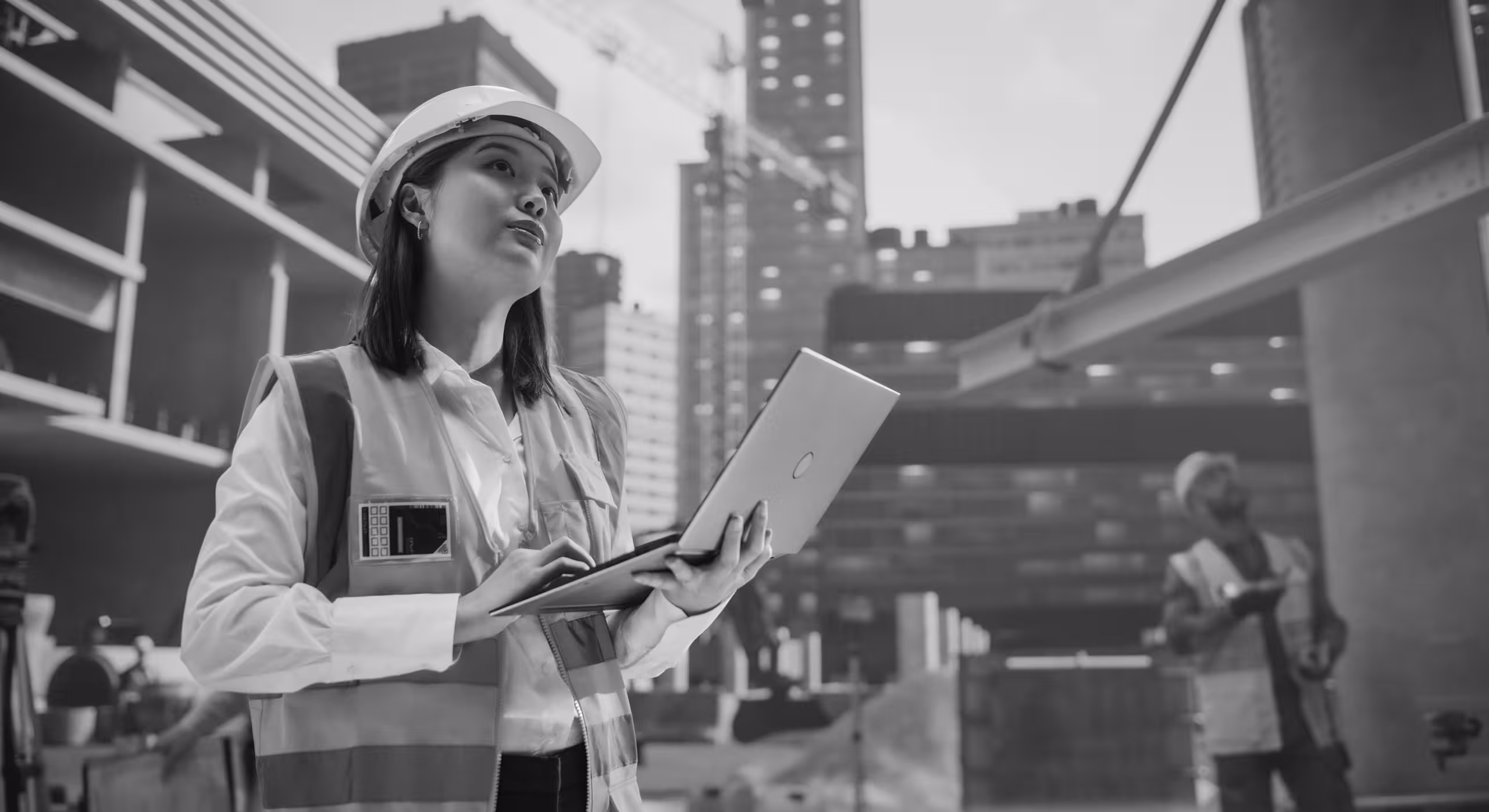 a woman in a hard hat holding a laptop