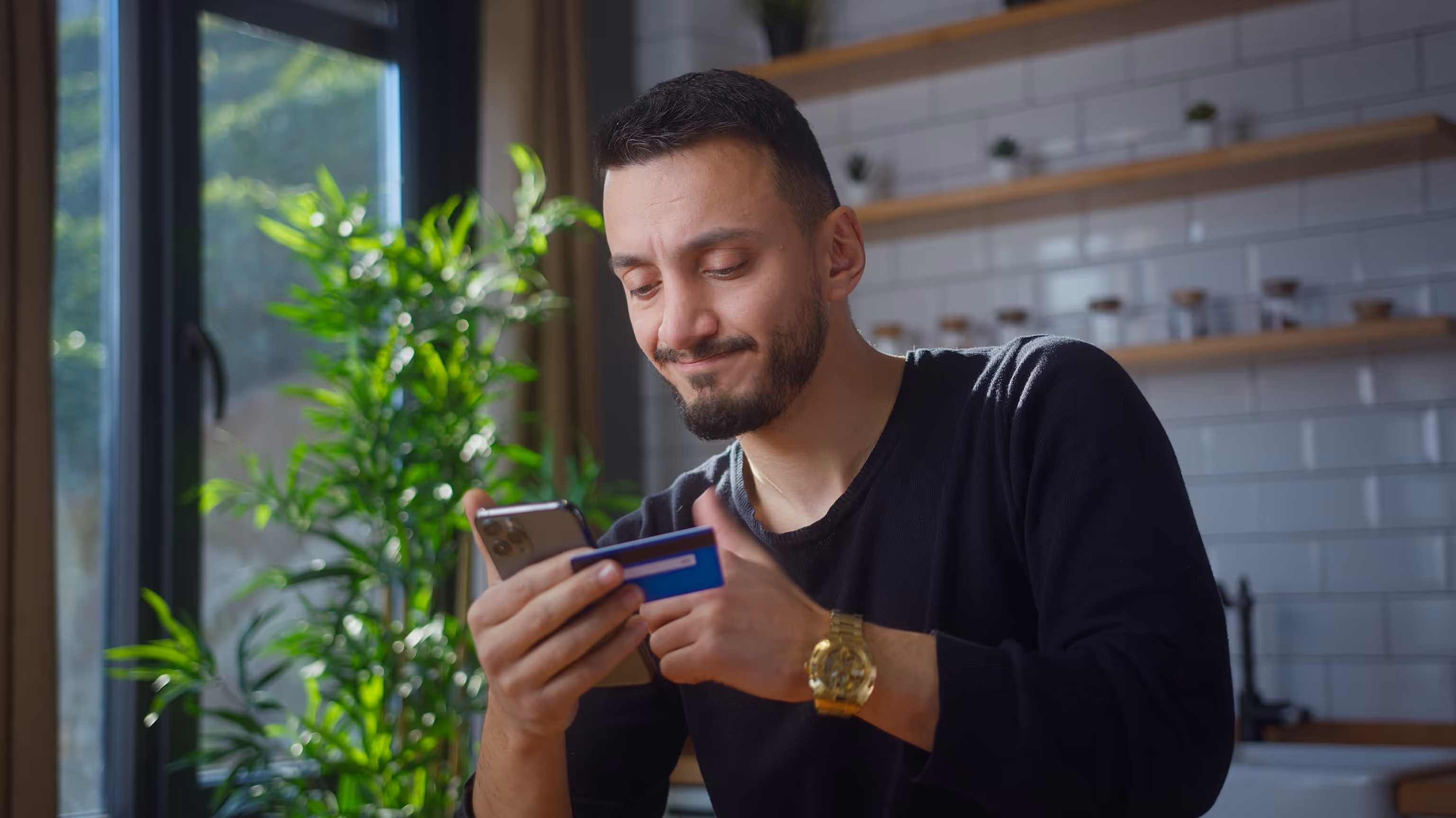 MCA NSF fees and bank withdrawal failures: A small business owner looks worried while checking his phone and credit card.