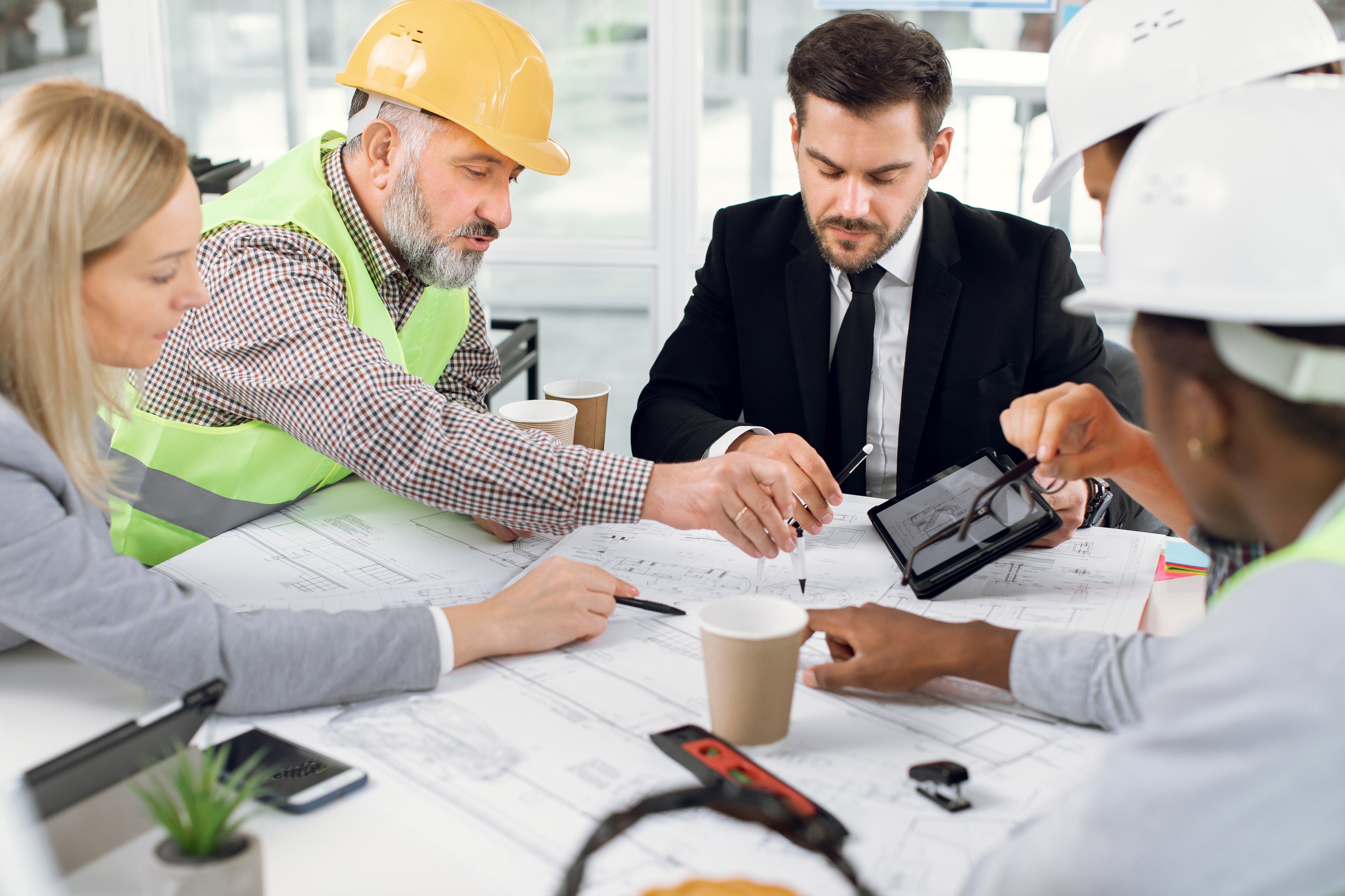 A construction project team discussing mca debt relief program with a specialist.