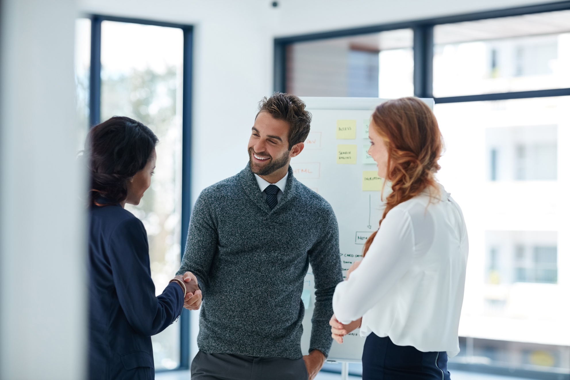 Business professionals shaking hands during a meeting, representing trust, transparency, ethical business practices, and strong client relationships in commercial debt relief and financial consulting.