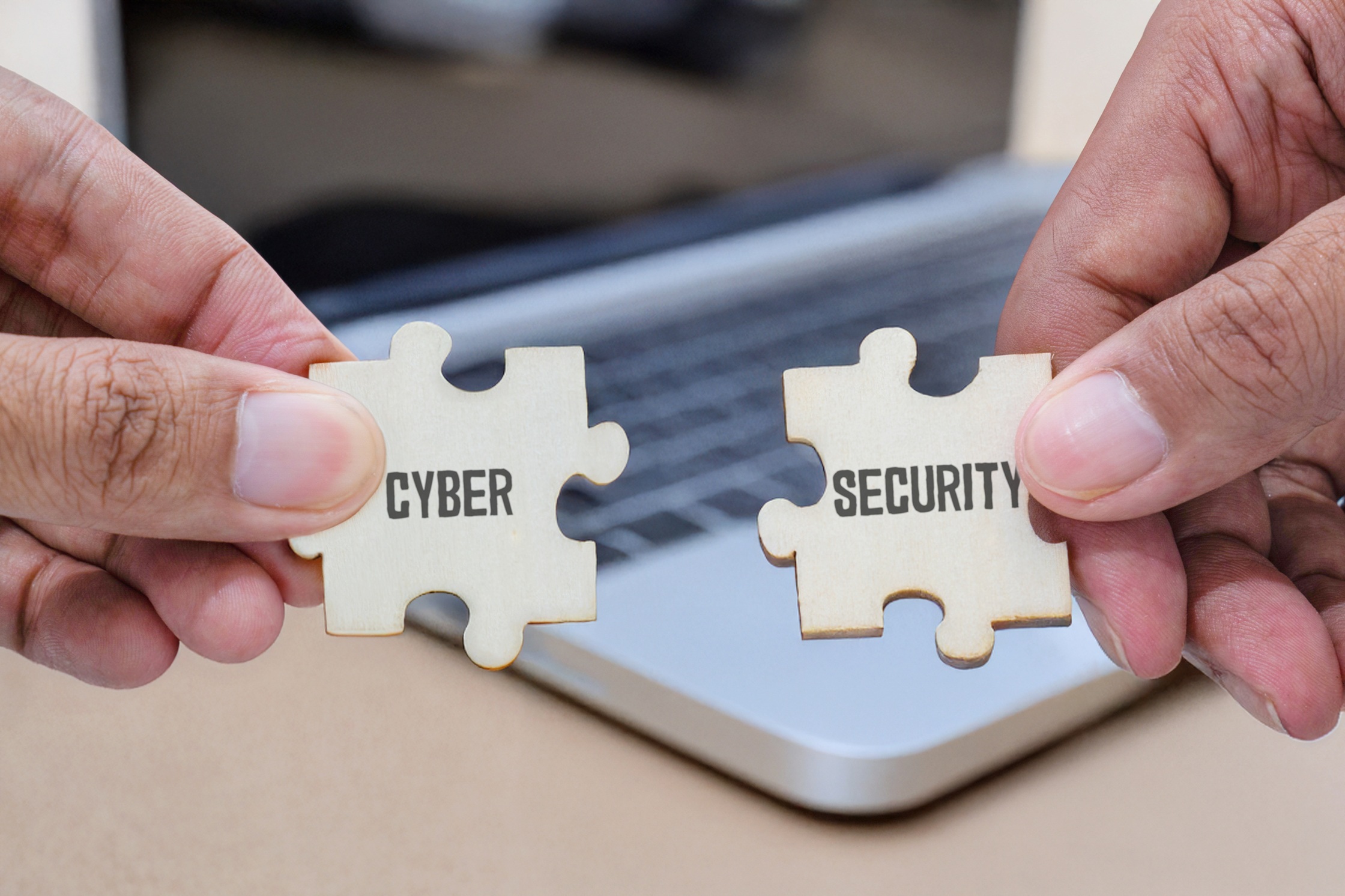 Hands connecting puzzle pieces labeled “Cyber” and “Security,” representing Coastal Debt Resolve’s commitment to protecting confidential business financial data with comprehensive cybersecurity measures.
