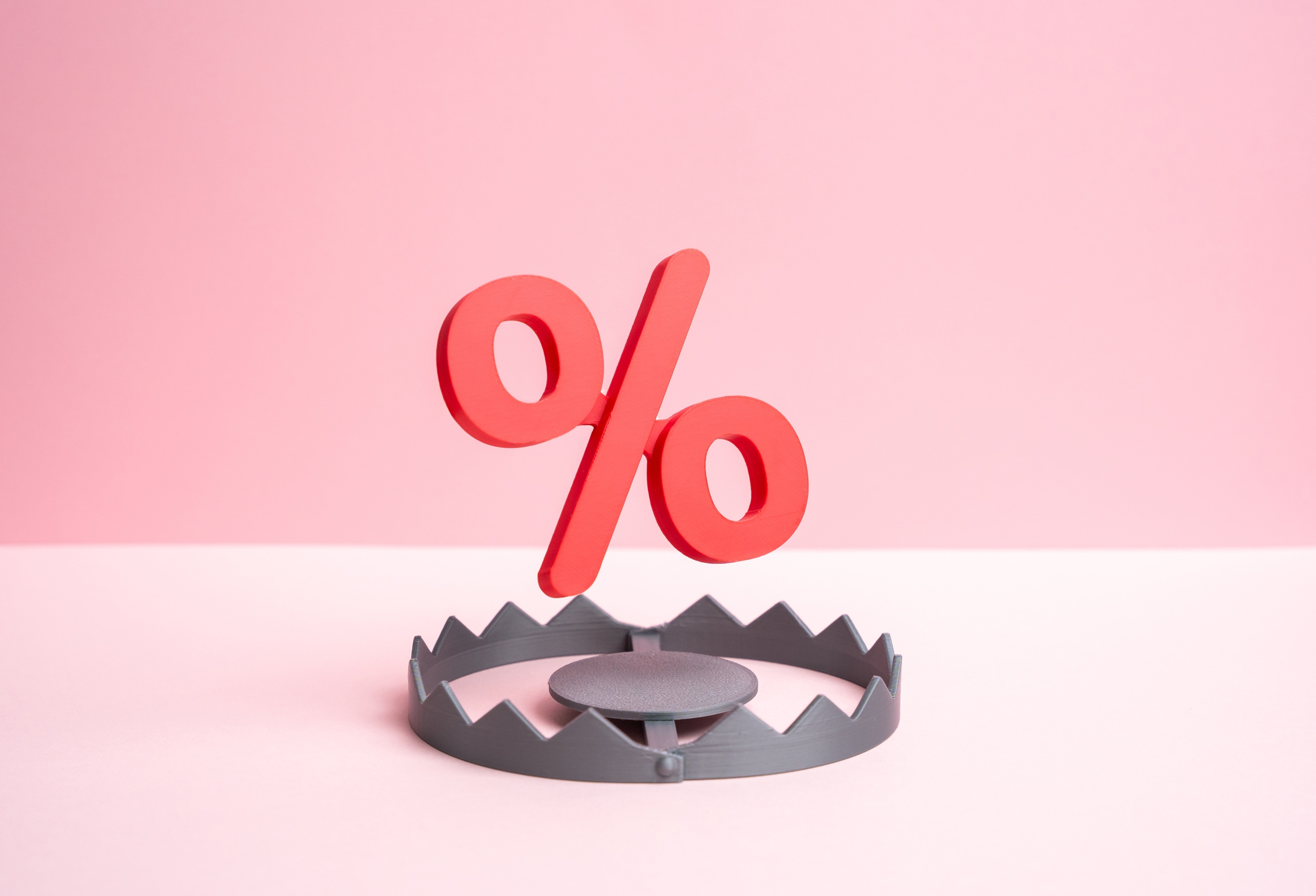 Percentage symbol above a bear trap illustrating the hidden costs and structural differences between merchant cash advances (MCAs) and traditional business loans, helping business owners better understand cash flow, cost considerations, and informed financial decision-making.