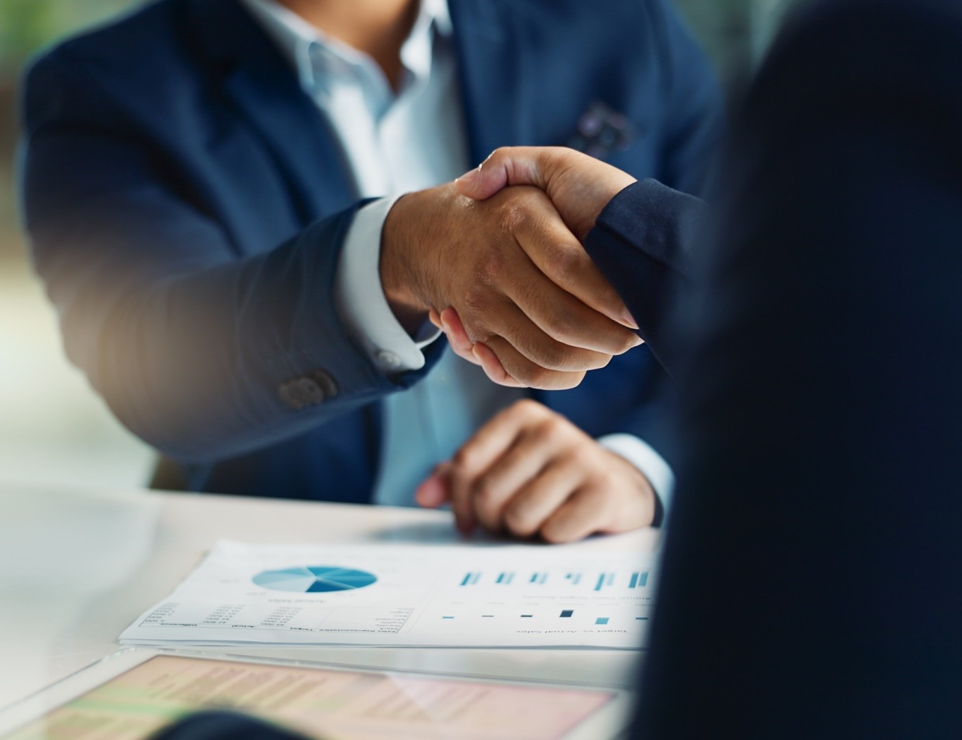 Business professionals shaking hands after reaching a negotiated MCA debt settlement with Coastal Debt Resolve.