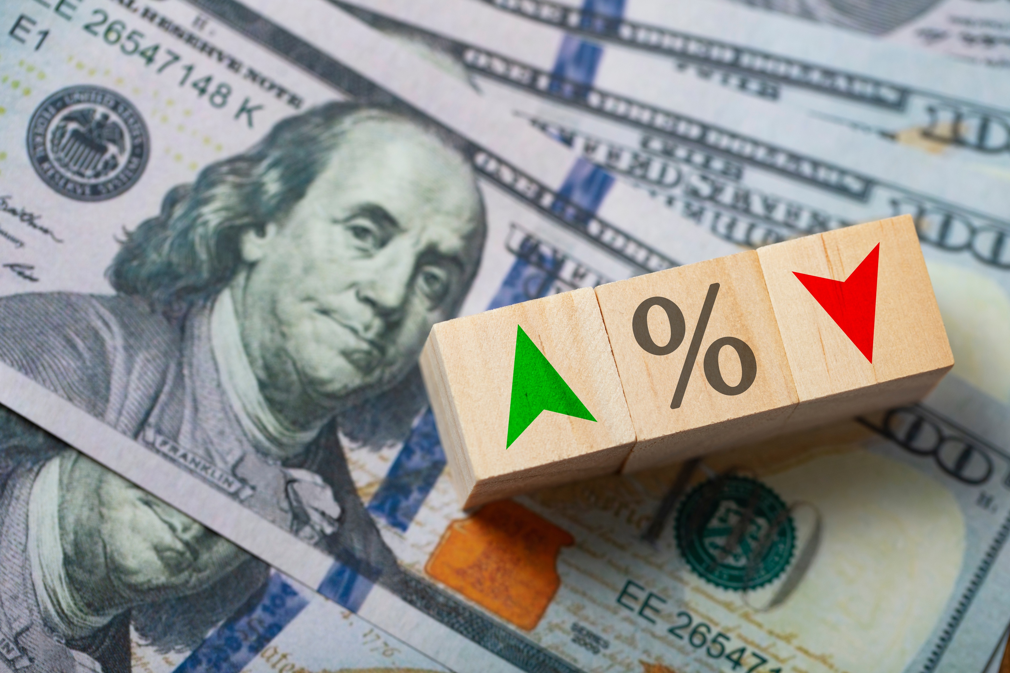 Hundred-dollar bills and rising and falling percentage symbols illustrate merchant cash advance rates discussed in Coastal Debt Resolve’s guide to California financing laws.