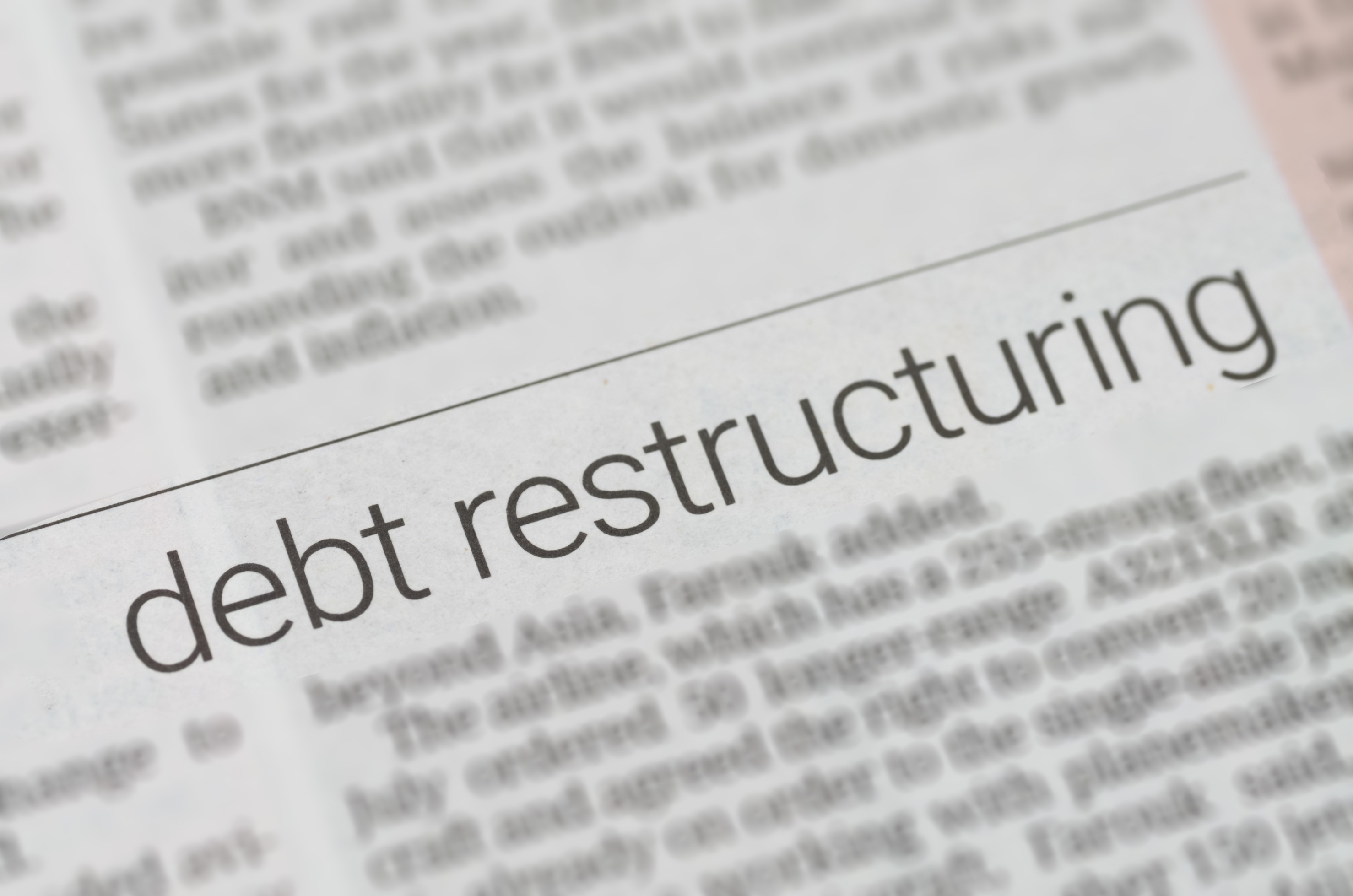 Close-up of the words “debt restructuring” in print, accompanying Coastal Debt Resolve’s comparison of restructuring and MCA reconciliation.