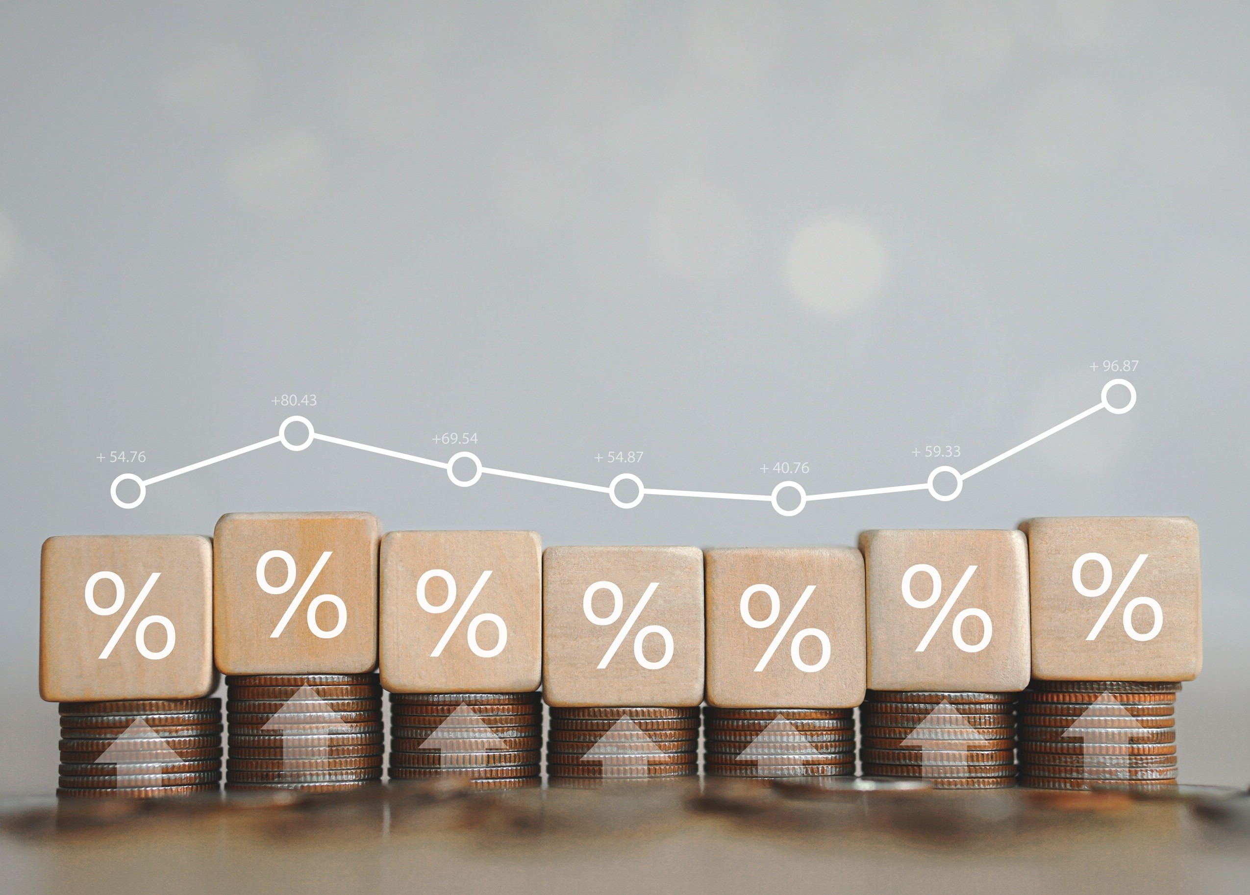 Percentage symbols above stacked coins, illustrating financing costs discussed in Coastal Debt Resolve’s MCA debt relief guide.