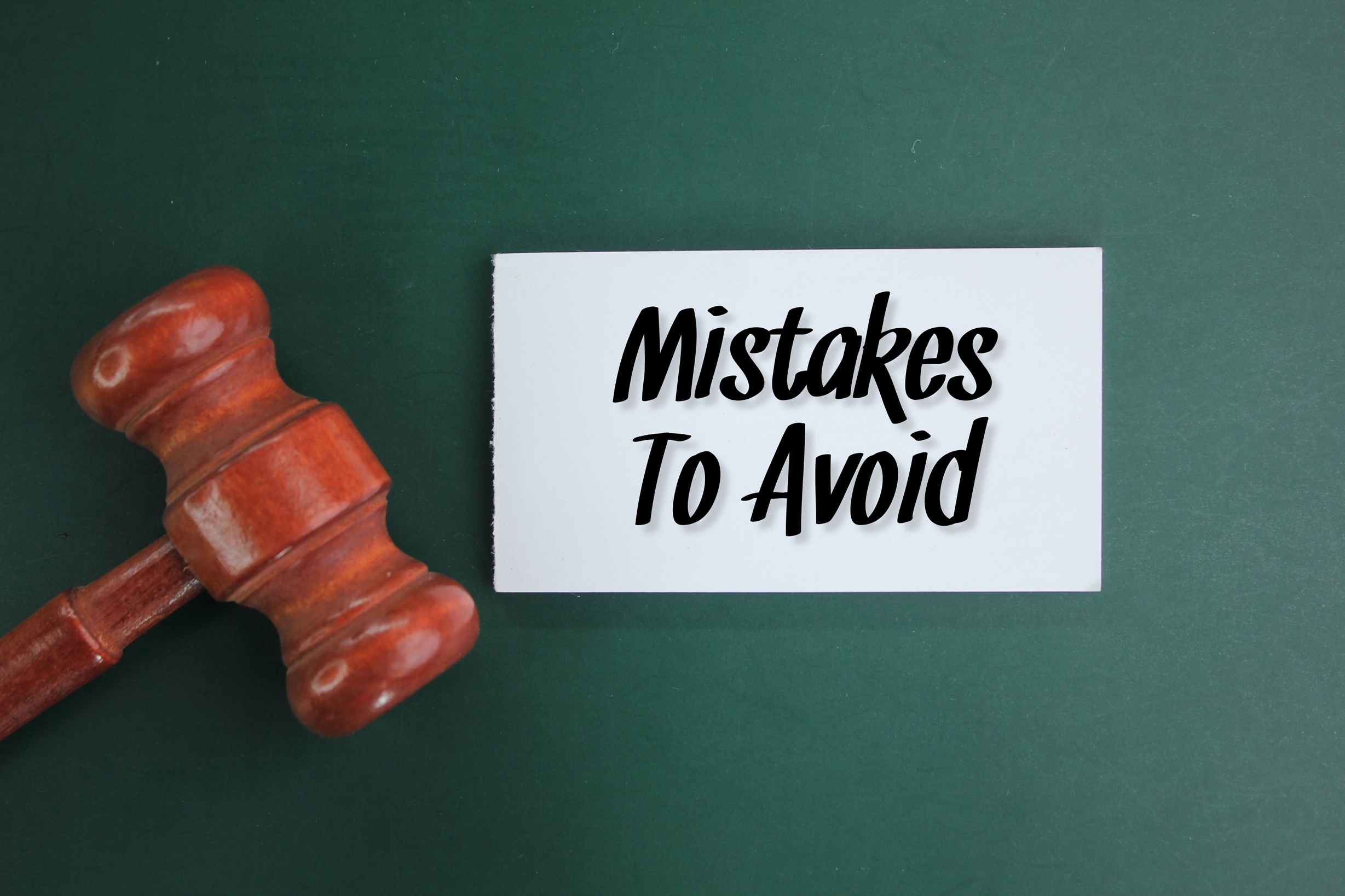 Judge's gavel and white paper with the words Mistakes To Avoid.