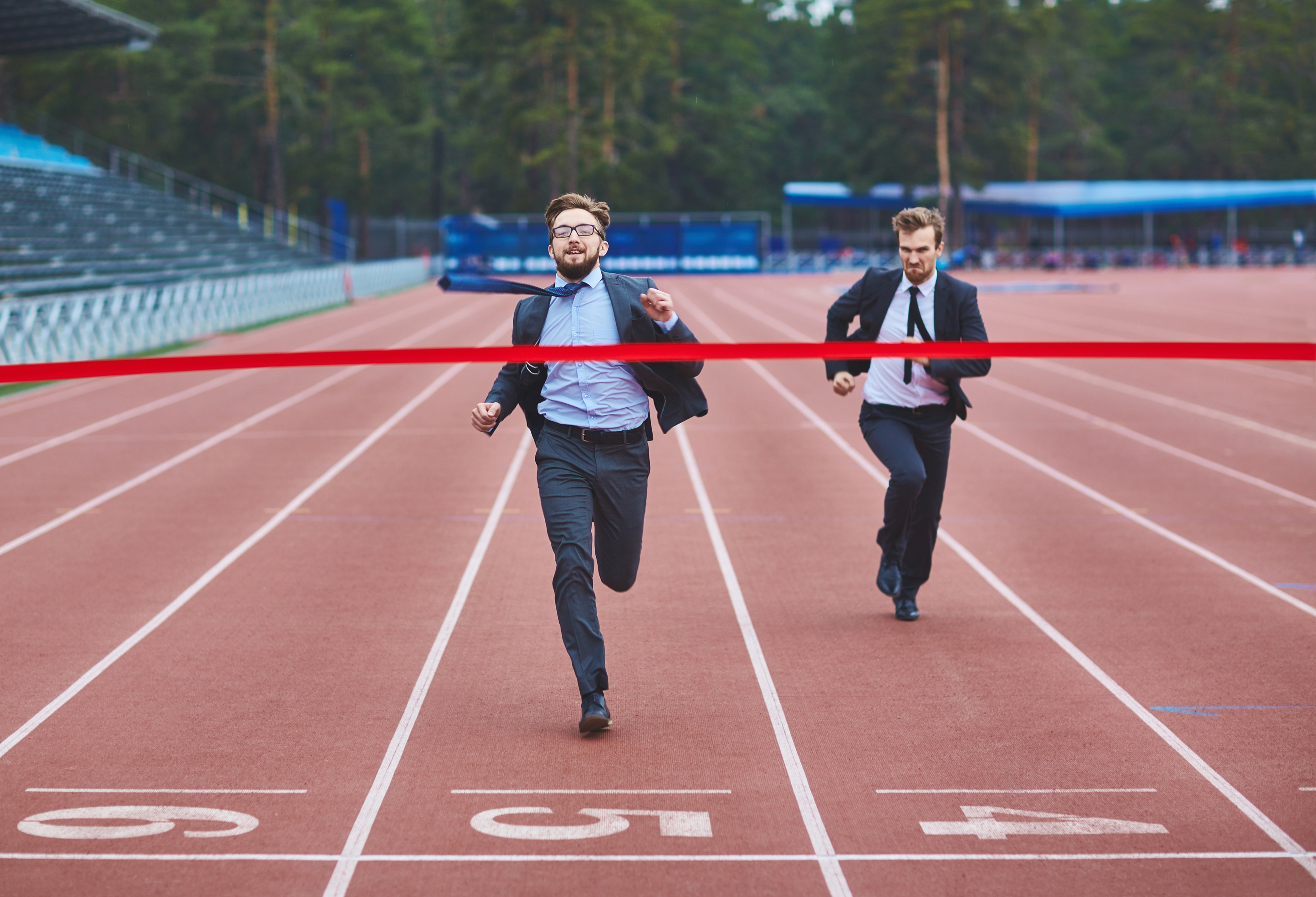Successful businessman reaching finish and winning competition representing competition between the top MCA companies.