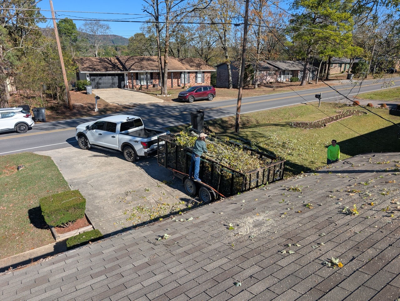 Tree removal loaded into trailer in front of house in central Arkansas