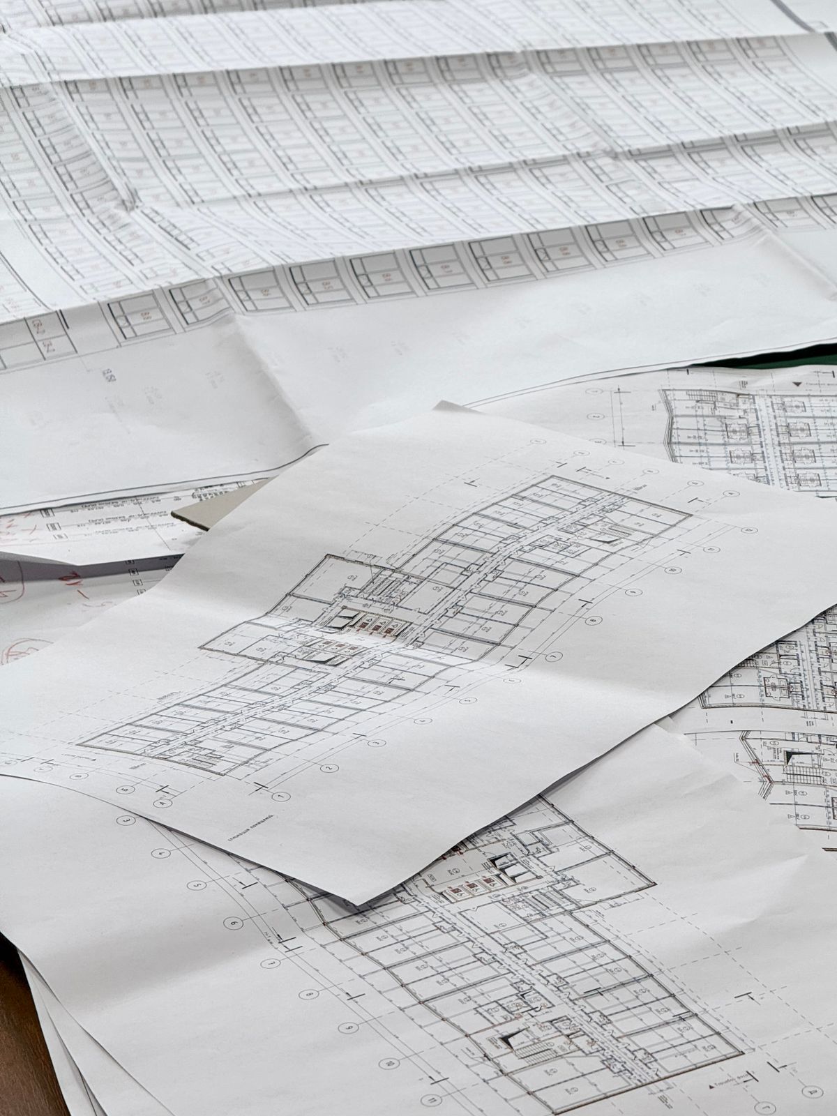 Architectural floor plan blueprints spread on a desk, representing room-by-room access point planning