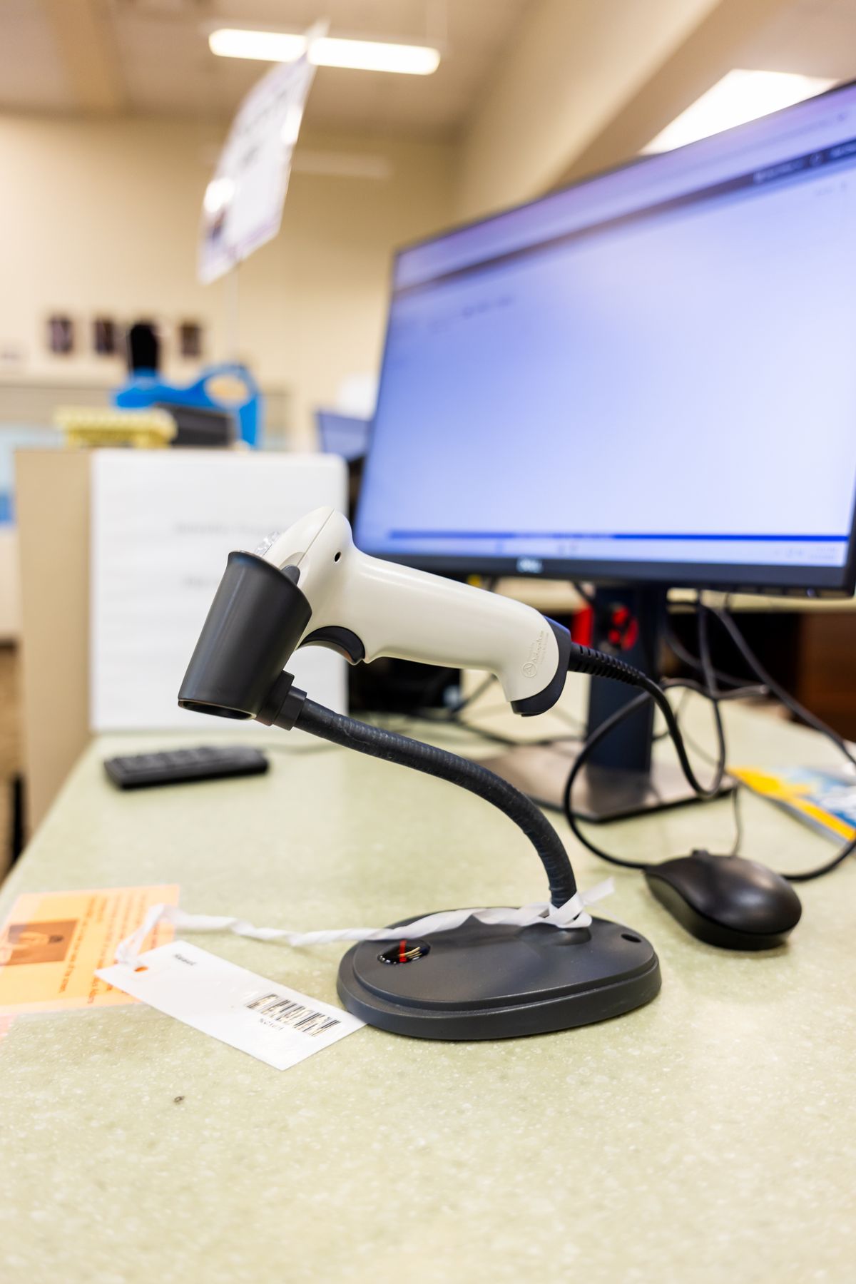 Barcode scanner tagging IT equipment on an office desk, representing IT asset management