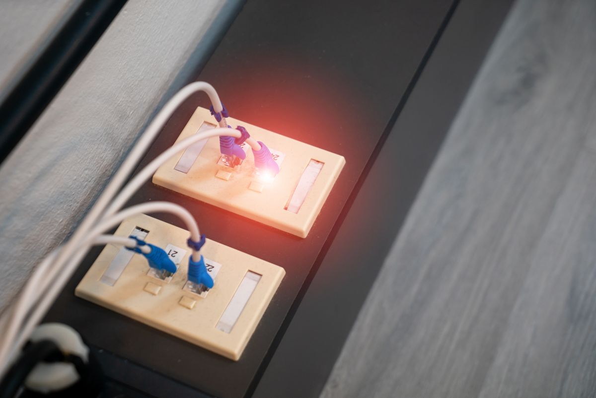 Close-up of plugged-in Ethernet ports with LED indicators, representing Power over Ethernet network infrastructure
