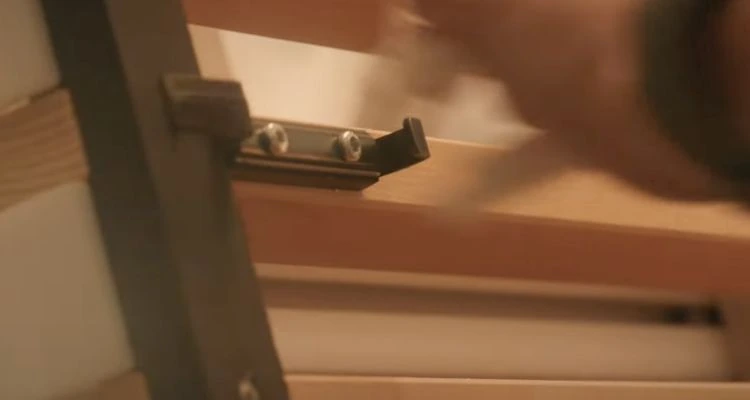 Gros plan du clip d’attache rapide fixé au panneau bois Ardemo, extrait du film