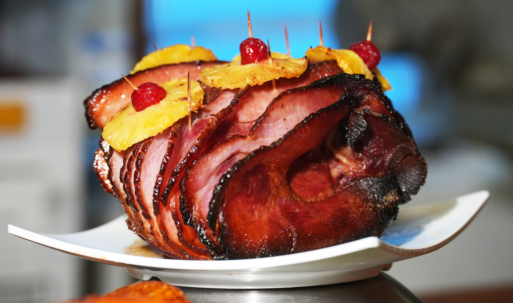 large roasted ham cut into slices with pineapple rings