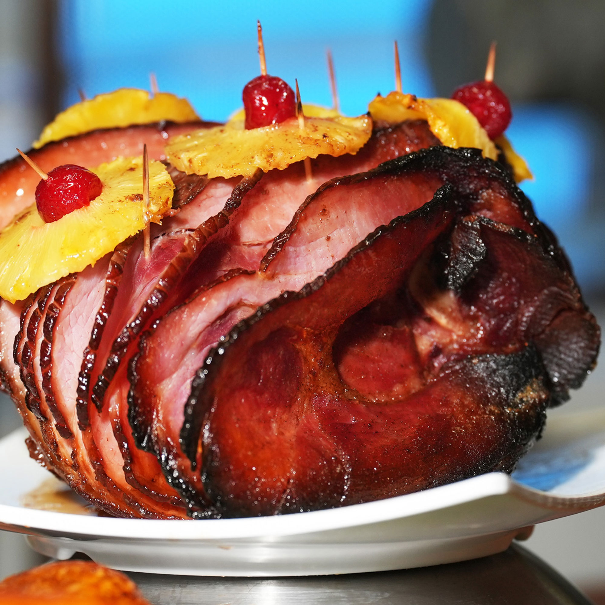 large roasted ham cut into slices with pineapple rings
