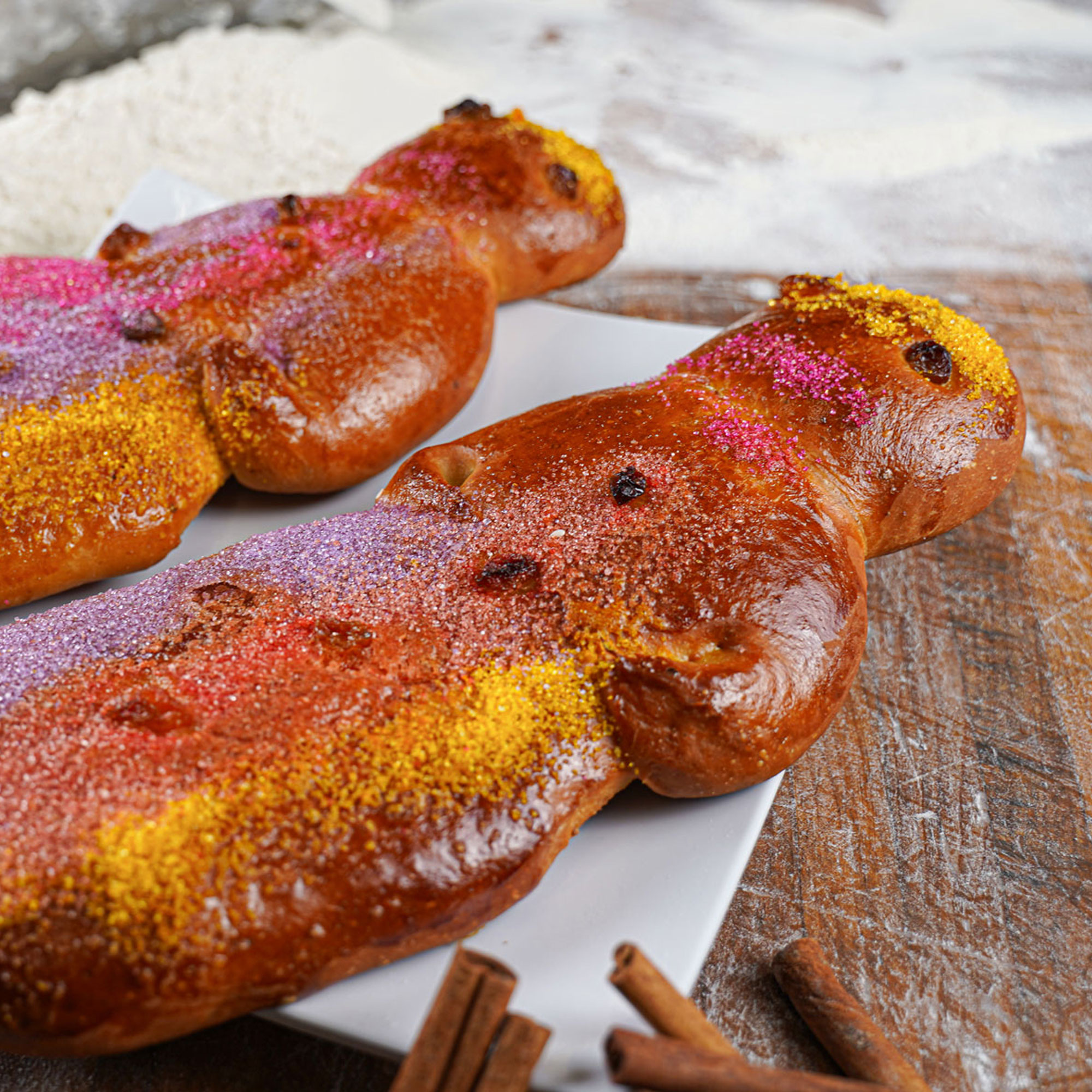 festive toasted person shaped bread topped with purple pink and yellow sugar