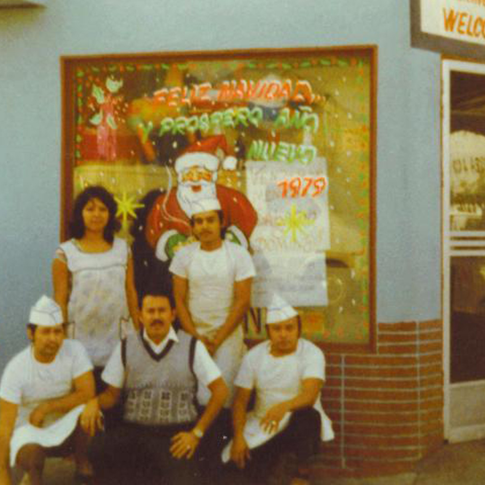 family standing in front of Christmas decorative window