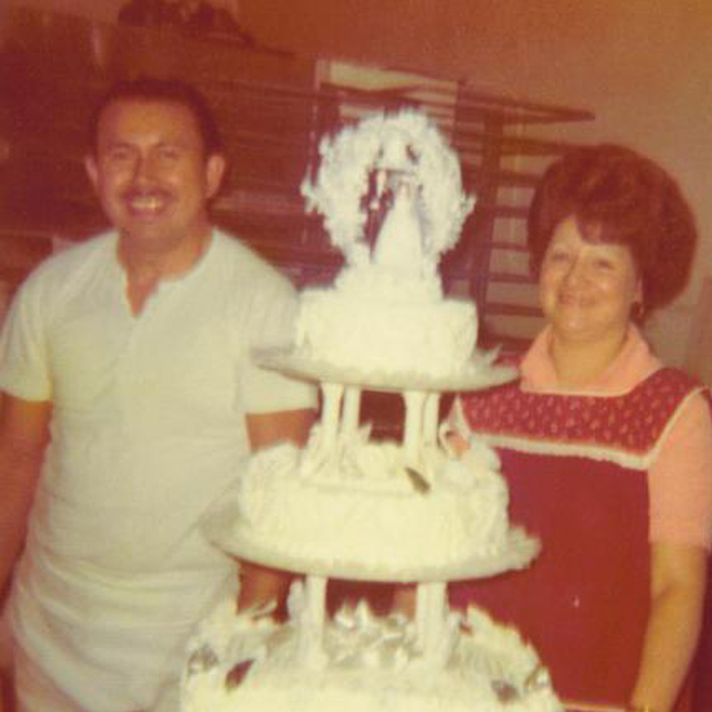 man and woman standing behind wedding cake