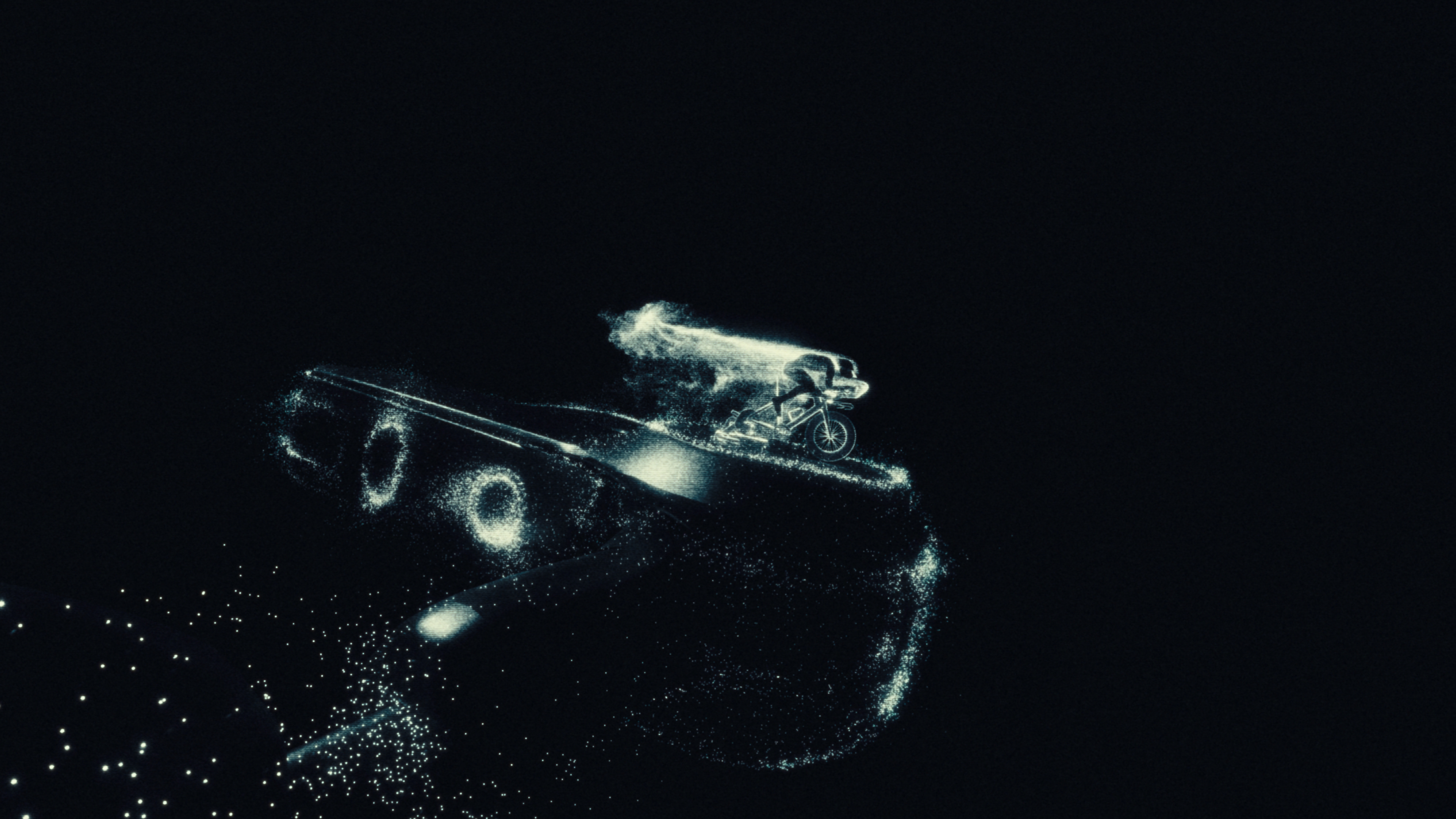 Cyclist rendered in glowing particles riding through darkness