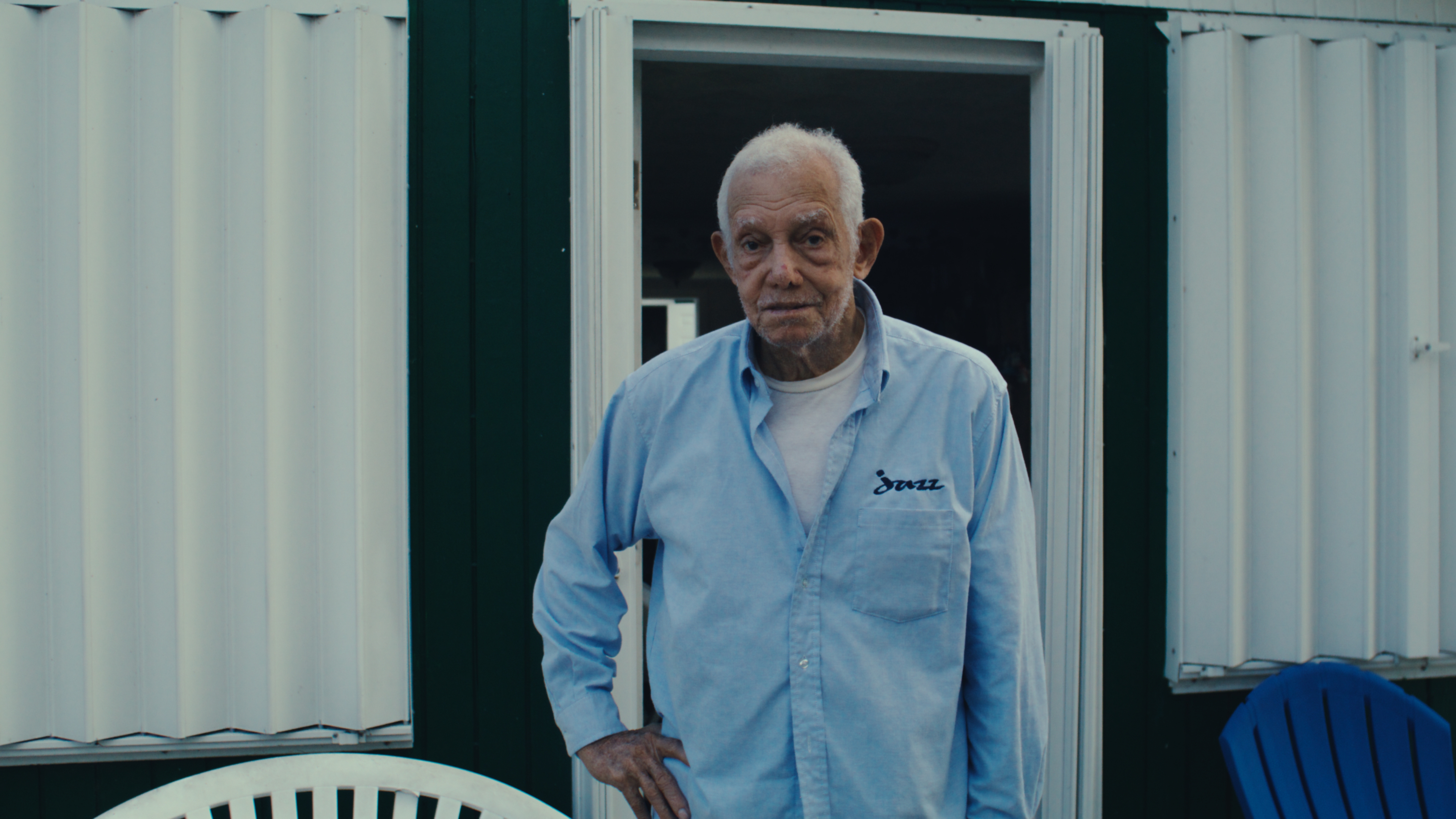 Elderly islander in a blue shirt standing in a doorway
