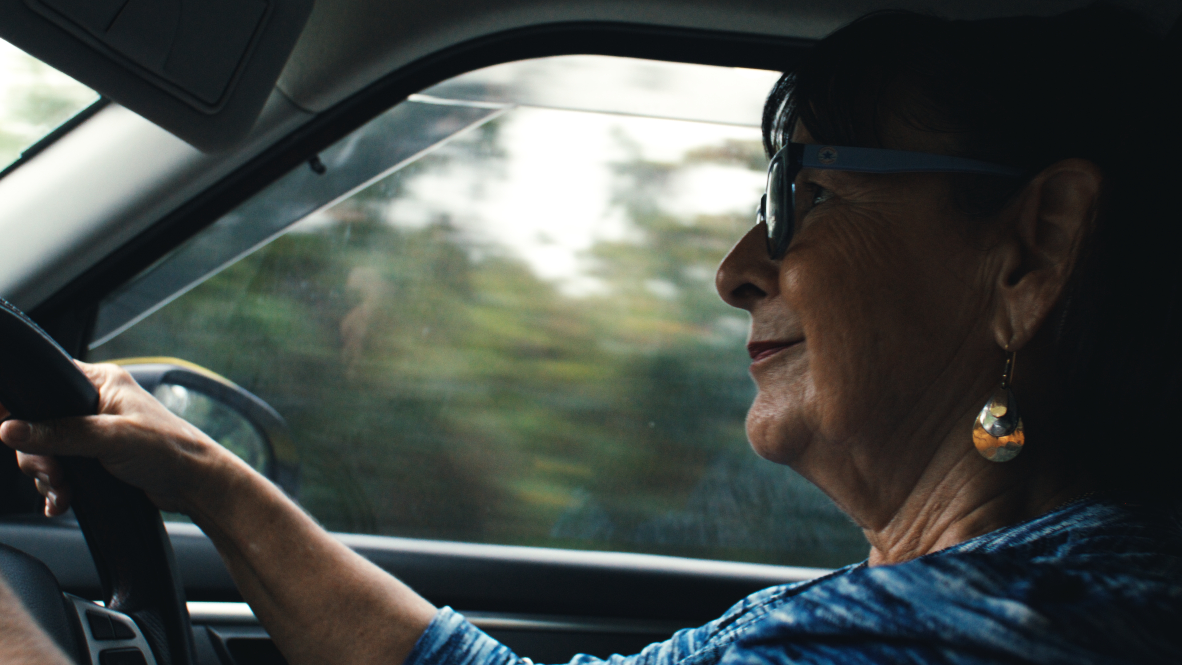 Woman in sunglasses driving on Cayman Brac