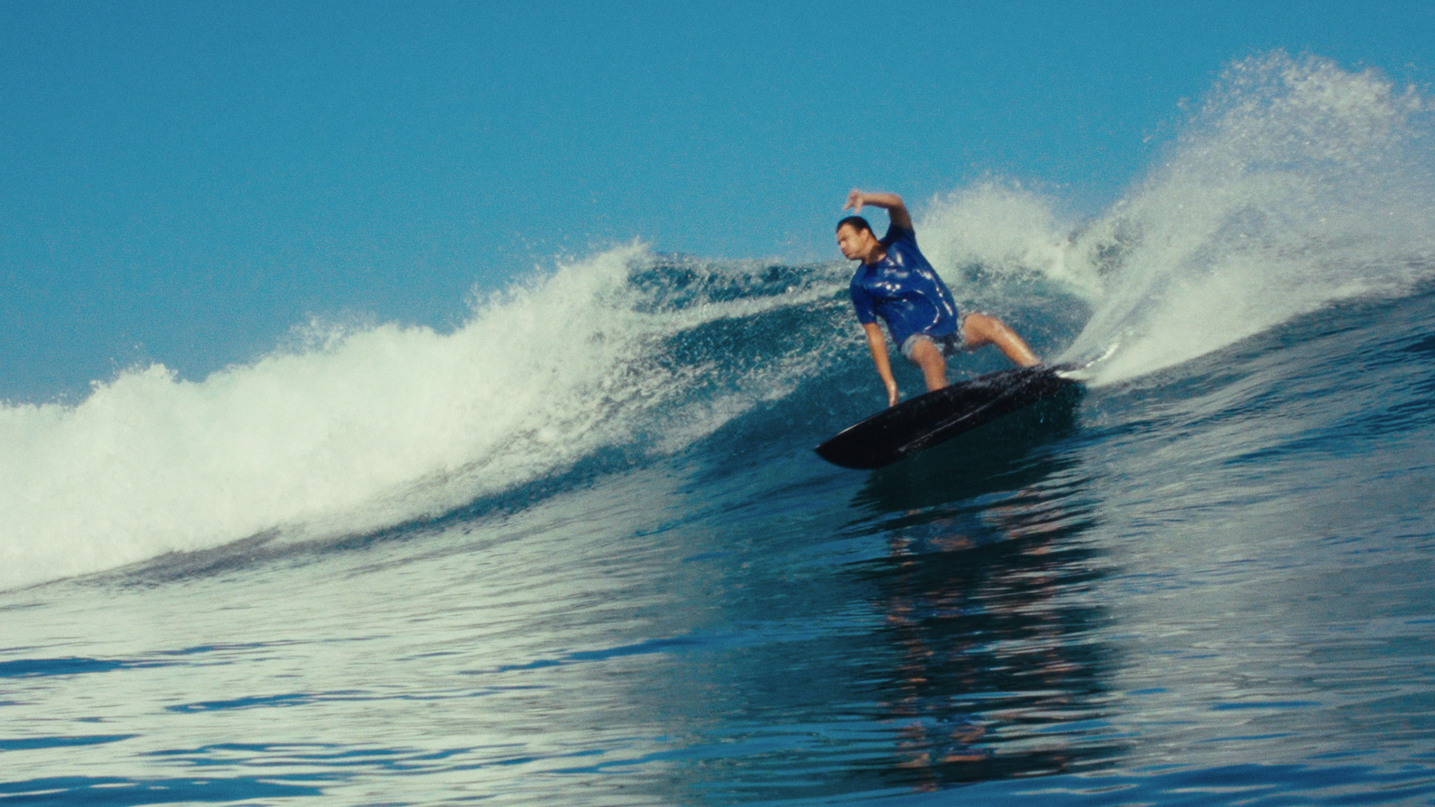 Surfer riding a clean breaking wave