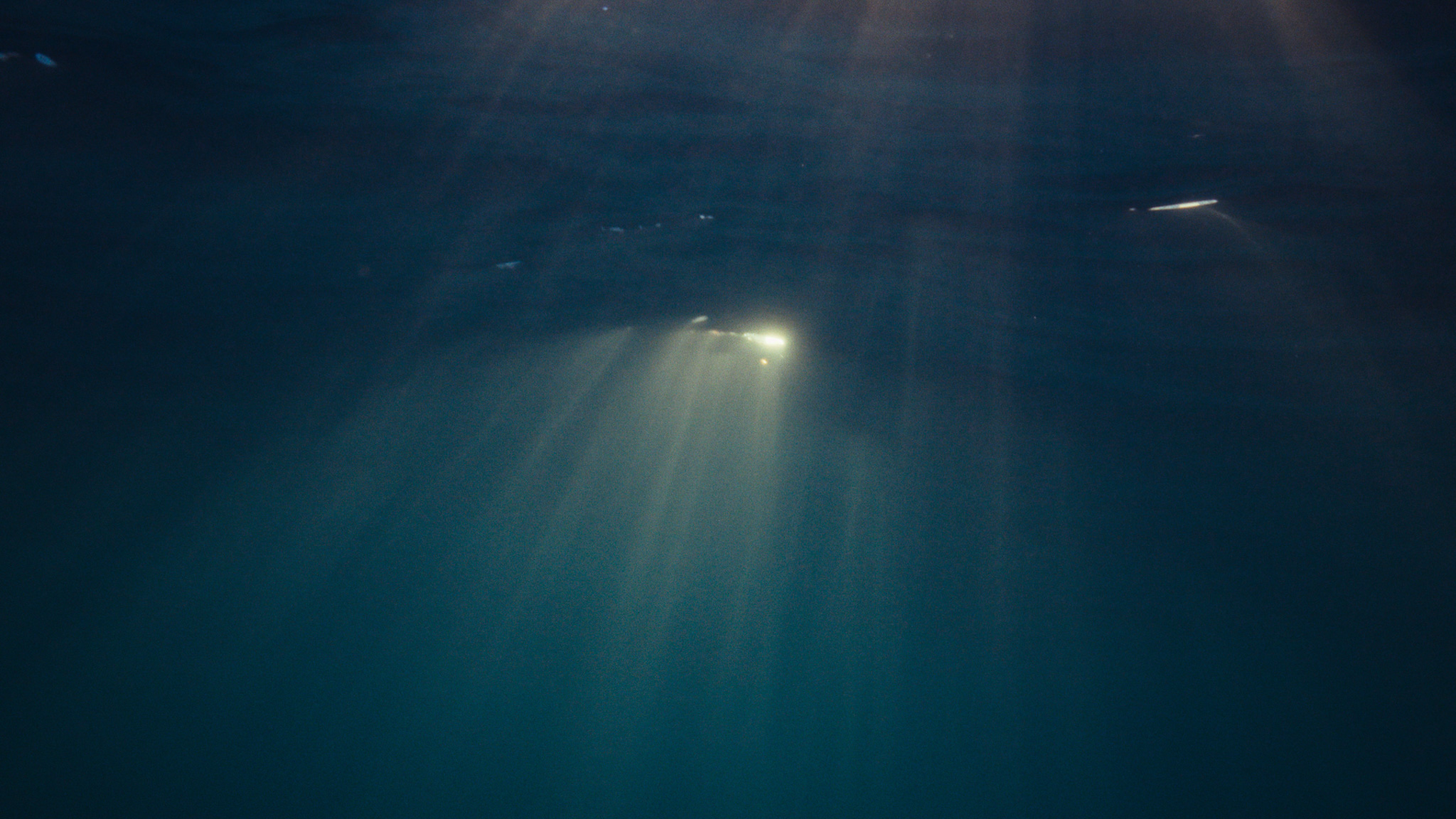 Rays of sunlight cutting through deep blue water
