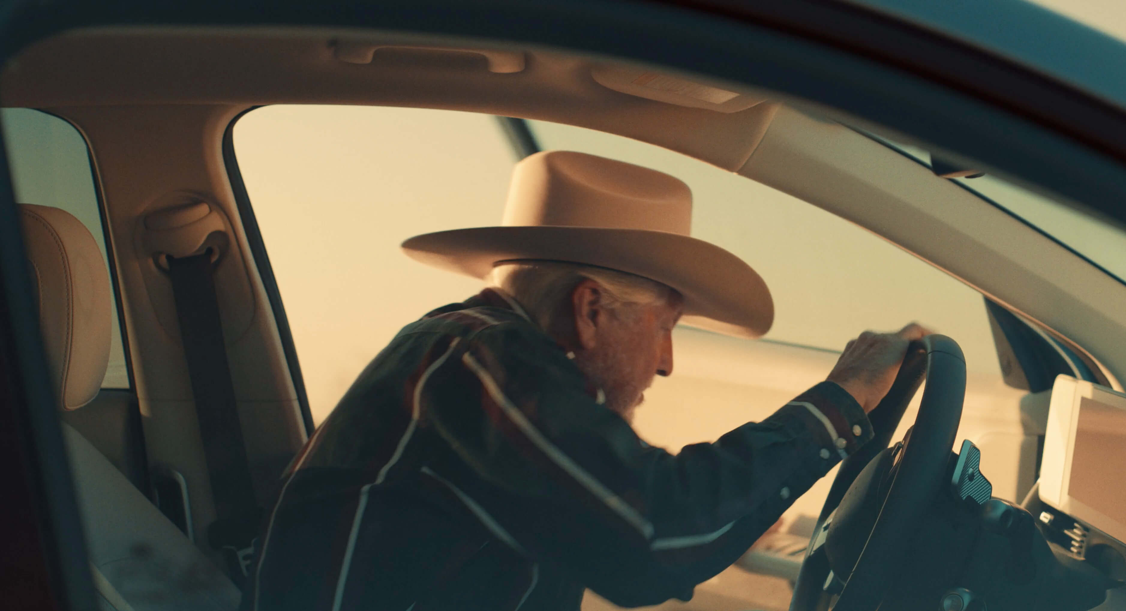 Cowboy at the wheel of a Hyundai IONIQ 5 at golden hour
