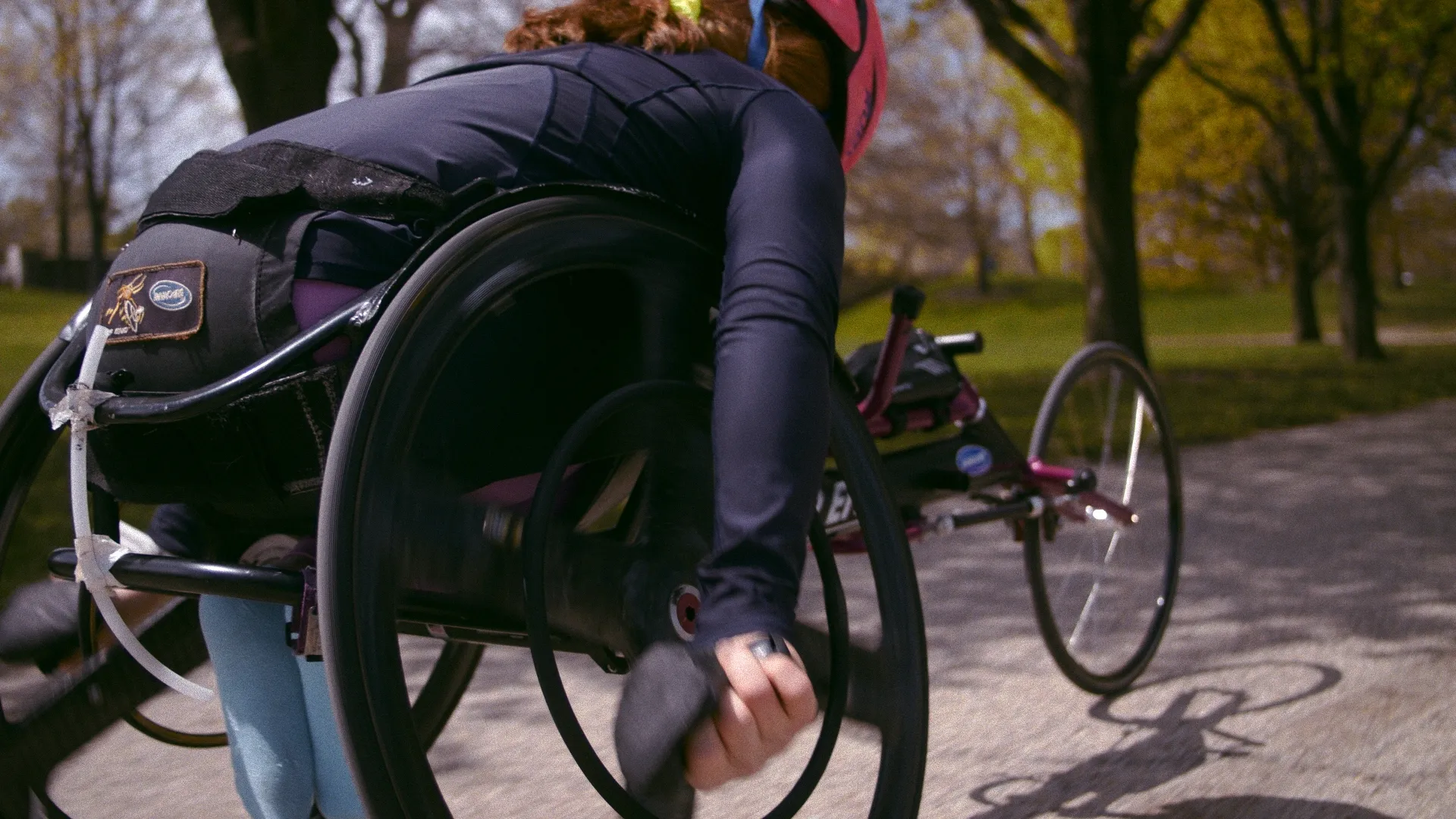Close-up of a racing wheelchair leaning through a turn in the park