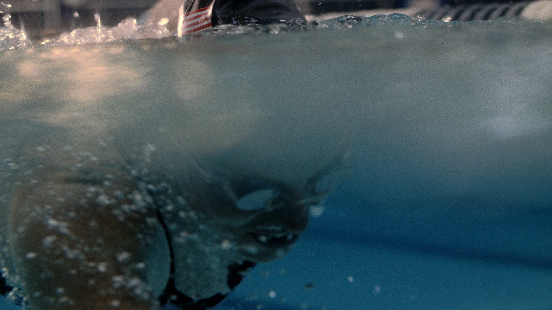 Underwater view of a swim stroke trailing bubbles