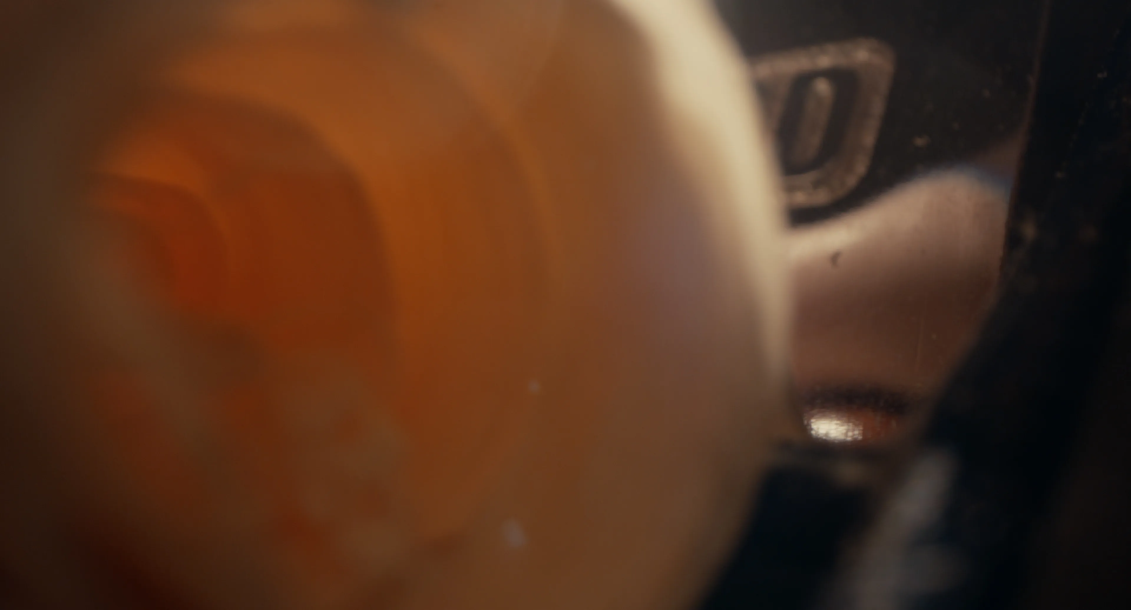Close-up of warm-toned guitar wood being shaped, softly blurred