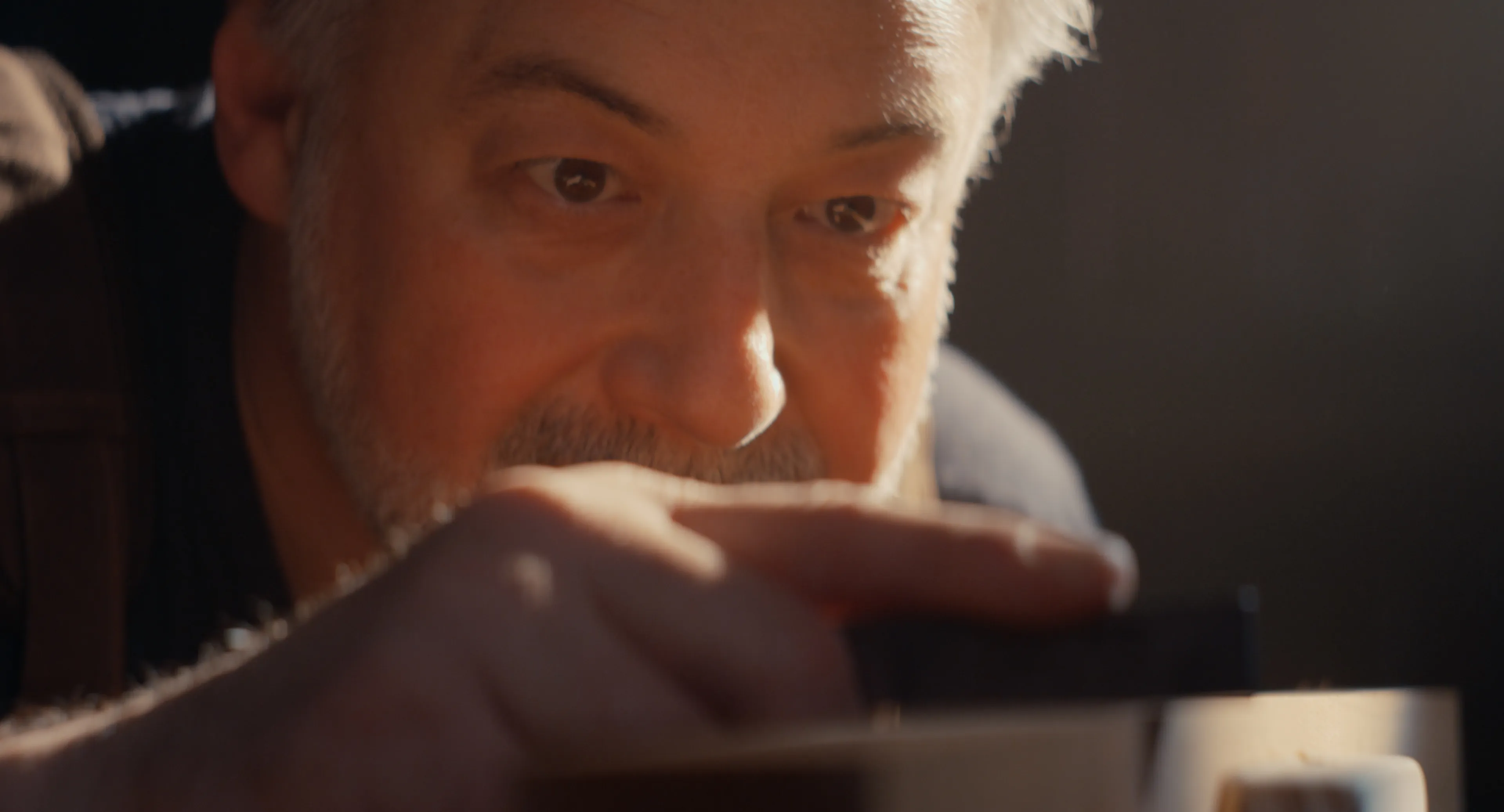 Close-up of a luthier inspecting a guitar neck at eye level