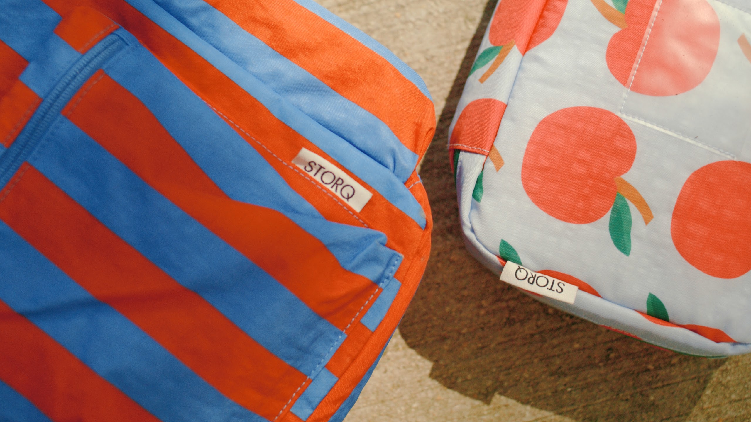 Striped STORQ backpack beside an apple print bag