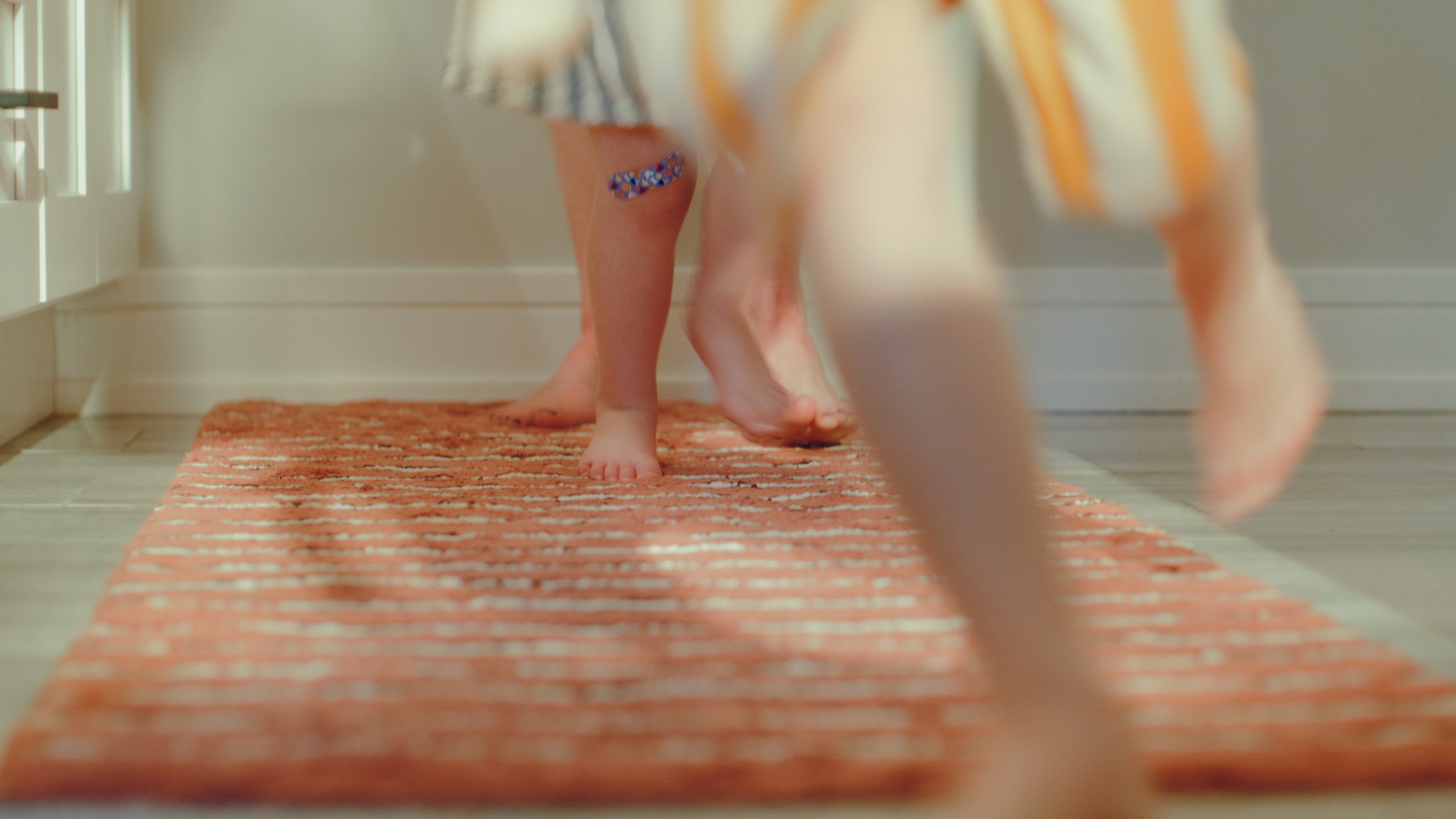 Small feet stepping across the rug