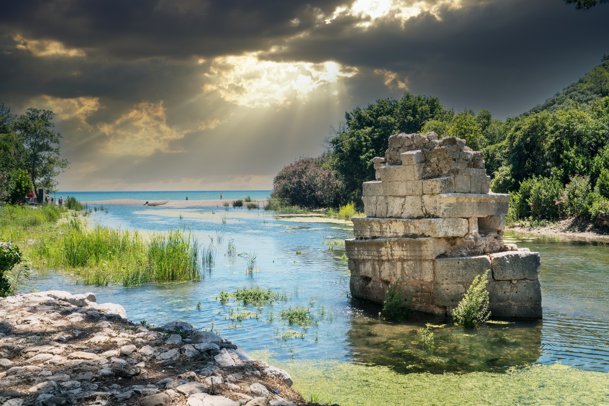 The harbor of Olympos Ruined City surrounded by lush greenery.