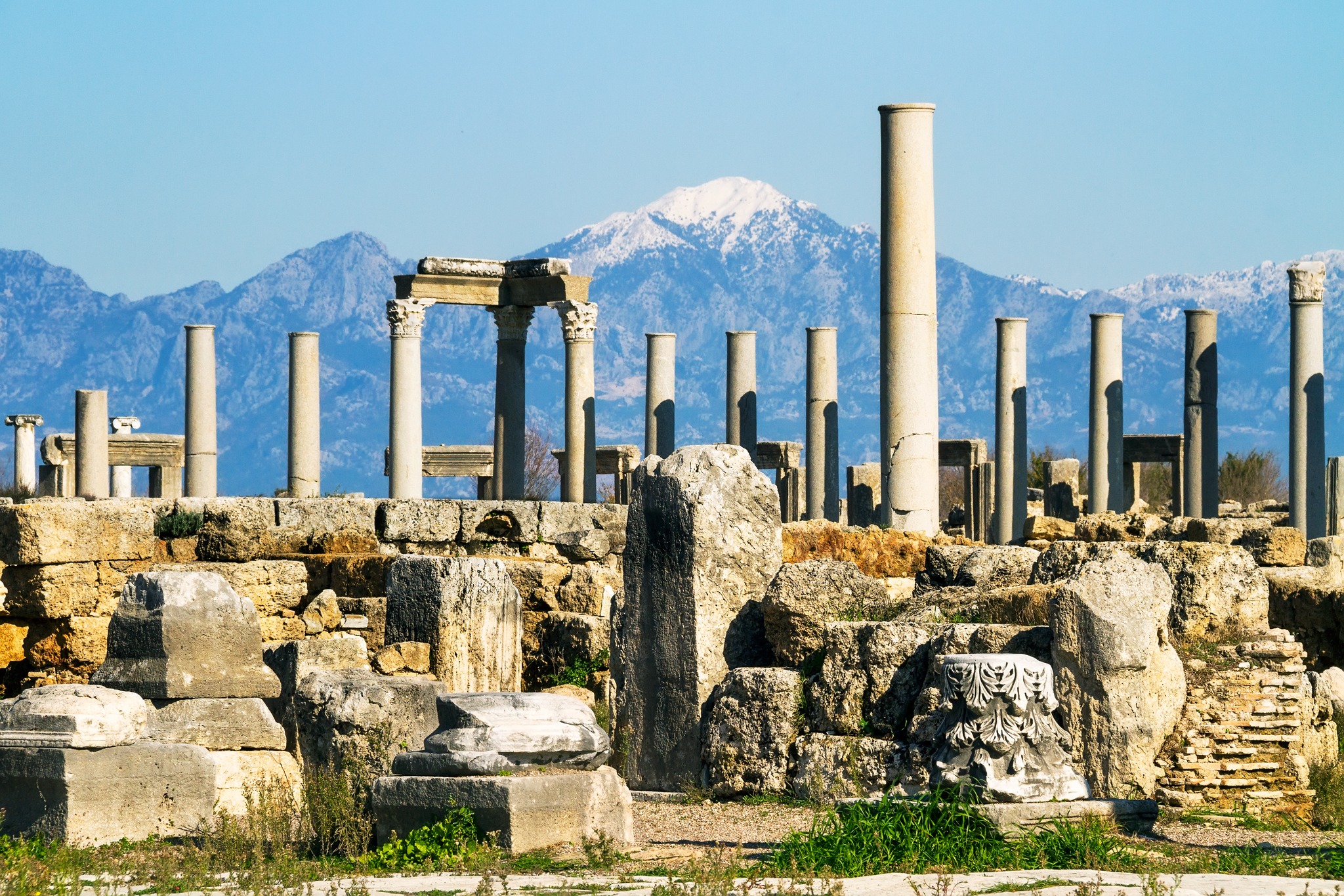 Tourists wandering among the towering columns of Perge Ancient City.