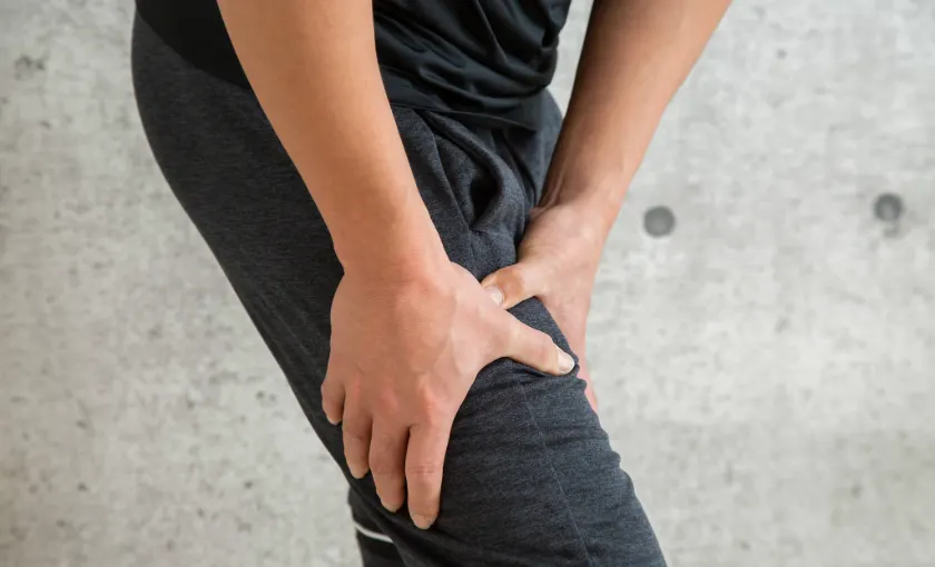 Person massaging numb leg due to poor circulation or early varicose vein symptoms