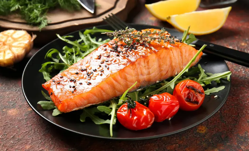 Healthy meal with salmon, citrus, and leafy greens to improve blood circulation and vein health.