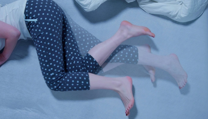 Woman fidgeting her legs at night due to restless leg syndrome