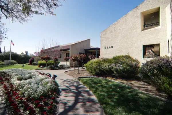 Front exterior of the BASS Vein Center Napa office at 3443 Villa Lane Suite 5, showing landscaped walkway, flowering plants, and the building entrance.