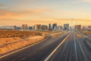 Las Vegas skyline at sunrise with a highway leading through the Nevada desert toward the city, symbolizing international business expansion and entry into the U.S. market.