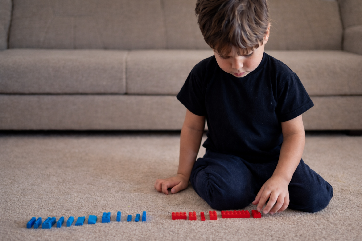 A young boy sorting lego on the floor