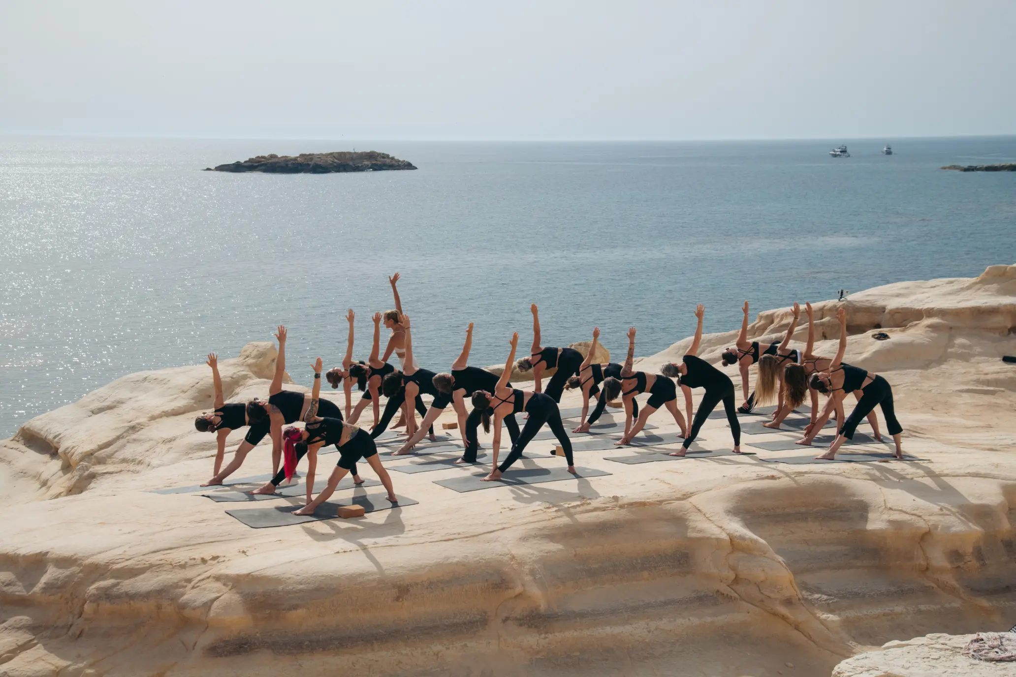 Gruppe der Yogalehrer Ausbildung in der Krieger-Haltung auf der Outdoor-Shala der Mysha Mansion auf Zypern