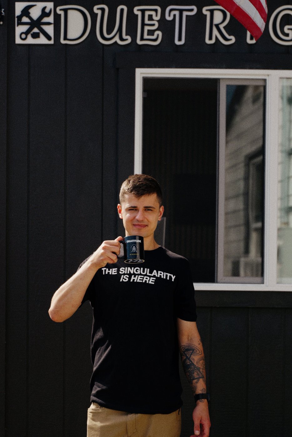 Stan holding a coffee mug under the DuetRight sign