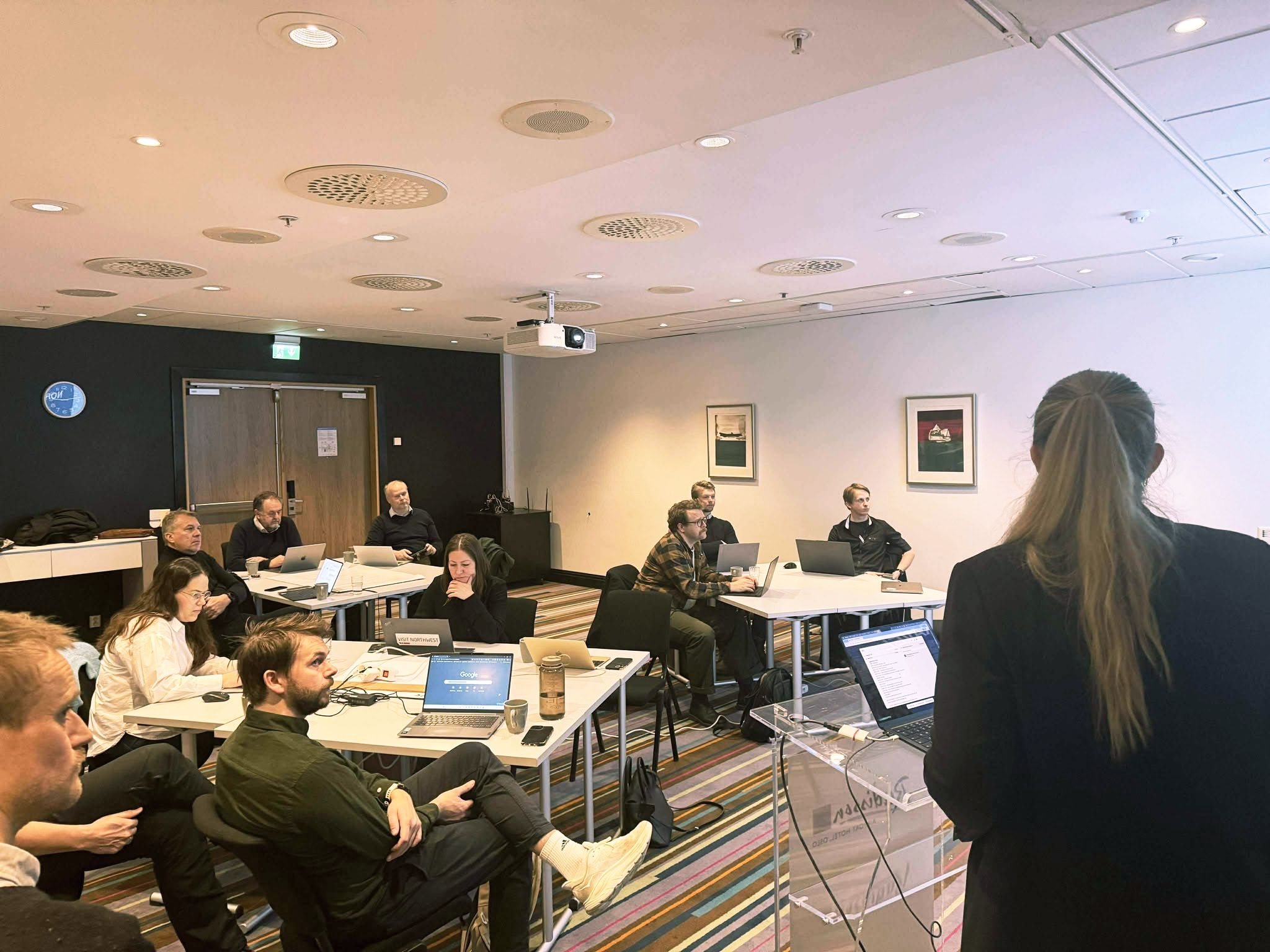 mange personar i eit møterom for diskusjon