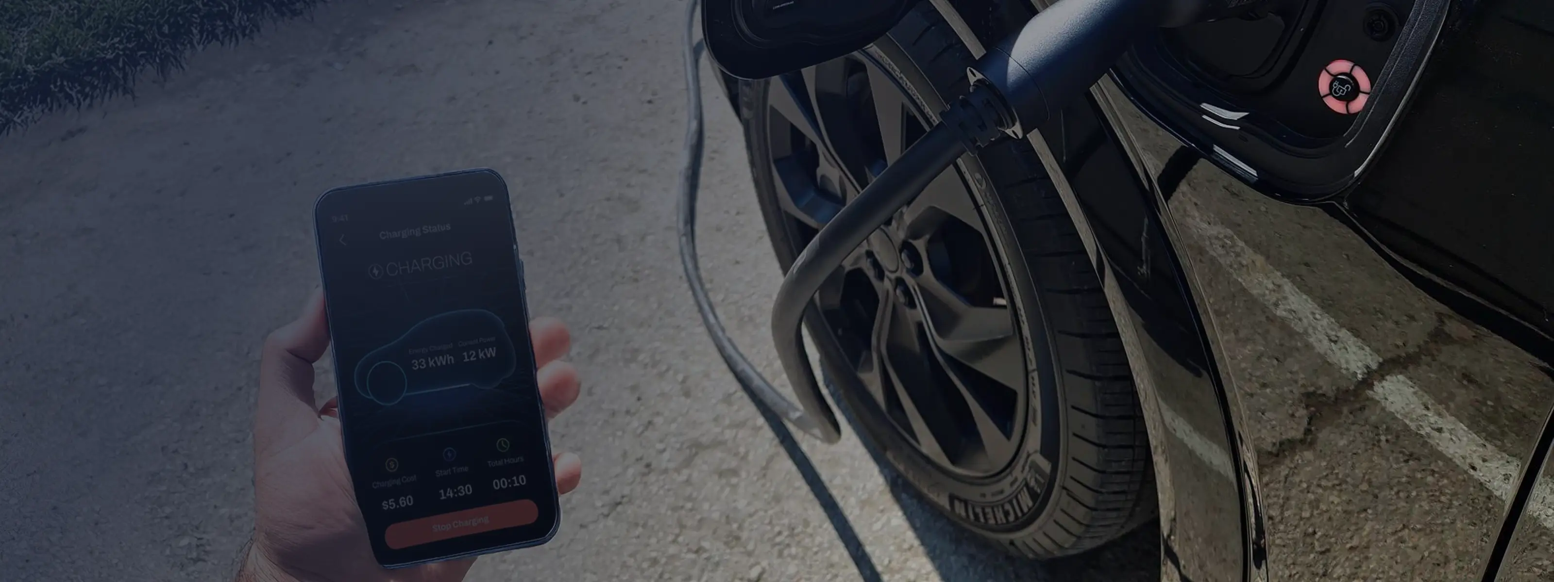 Hand holding smartphone displaying electric car charging status next to a black car with charging cable plugged in.