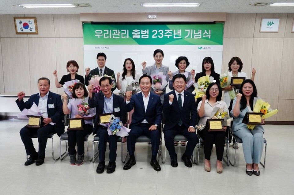 우리관리 출범 23주년 기념식에서 노병용 회장이 사업장 장기근속자들과 기념사진을 촬영하고 있다.
